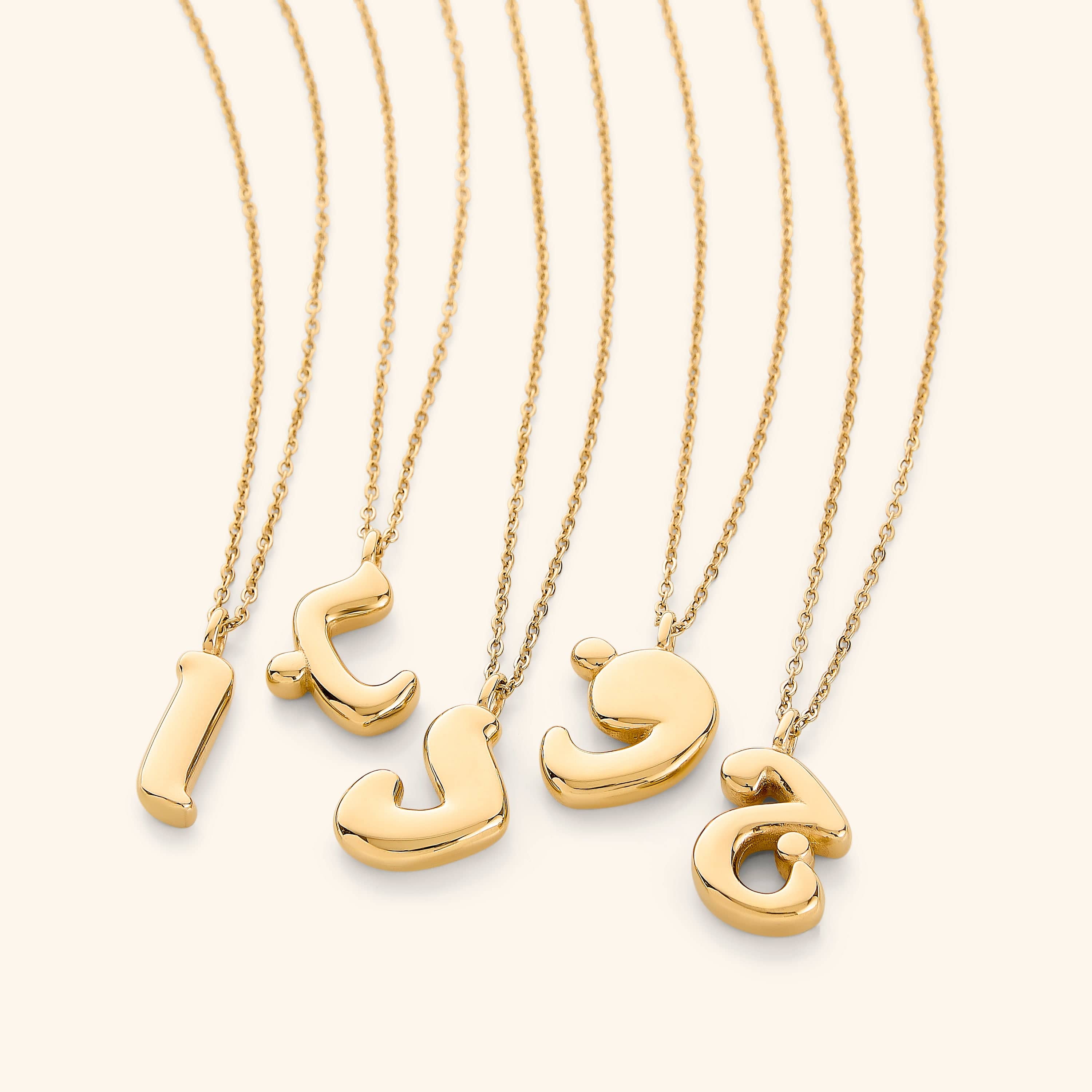 The Arabic bubble letter necklace displayed in a velvet pouch, ready for gift-giving.