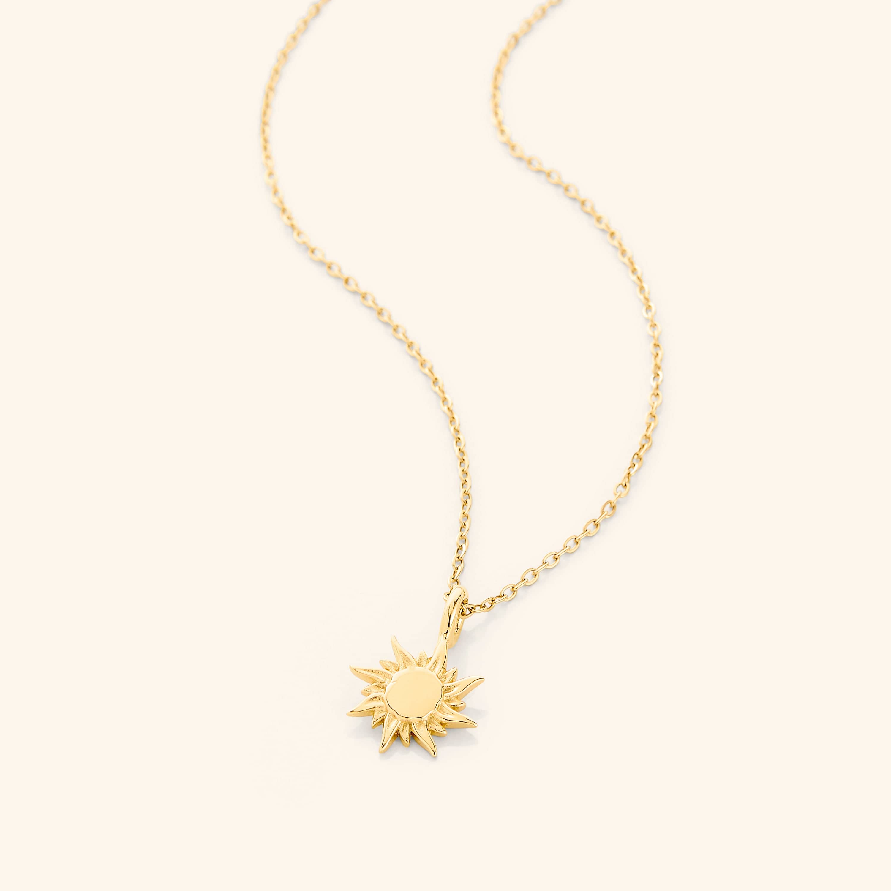 Radiant Sunrise Necklace with 18K gold plating, displayed elegantly on a velvet pouch.