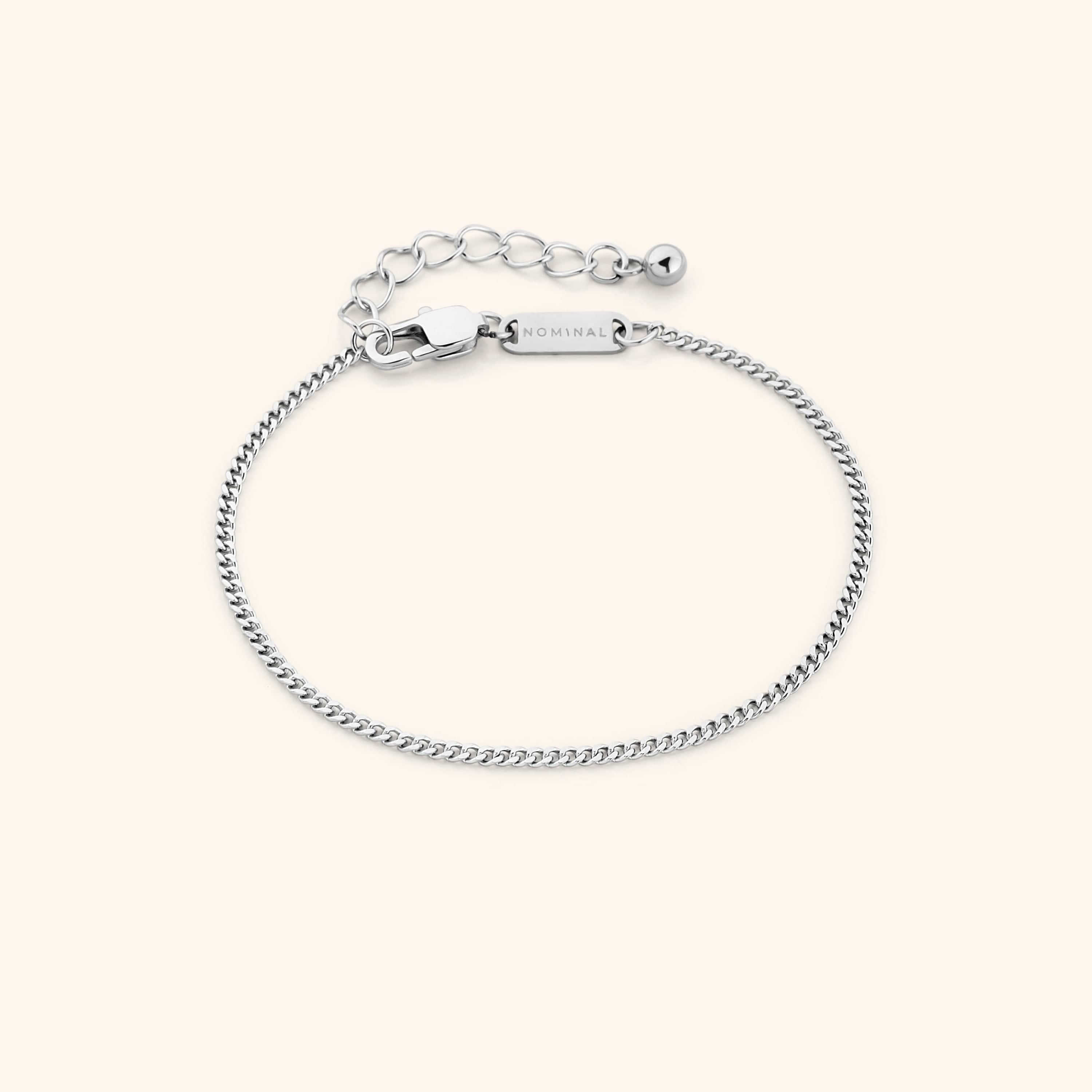 Elegant gold curb chain bracelet displayed in a velvet drawstring pouch.