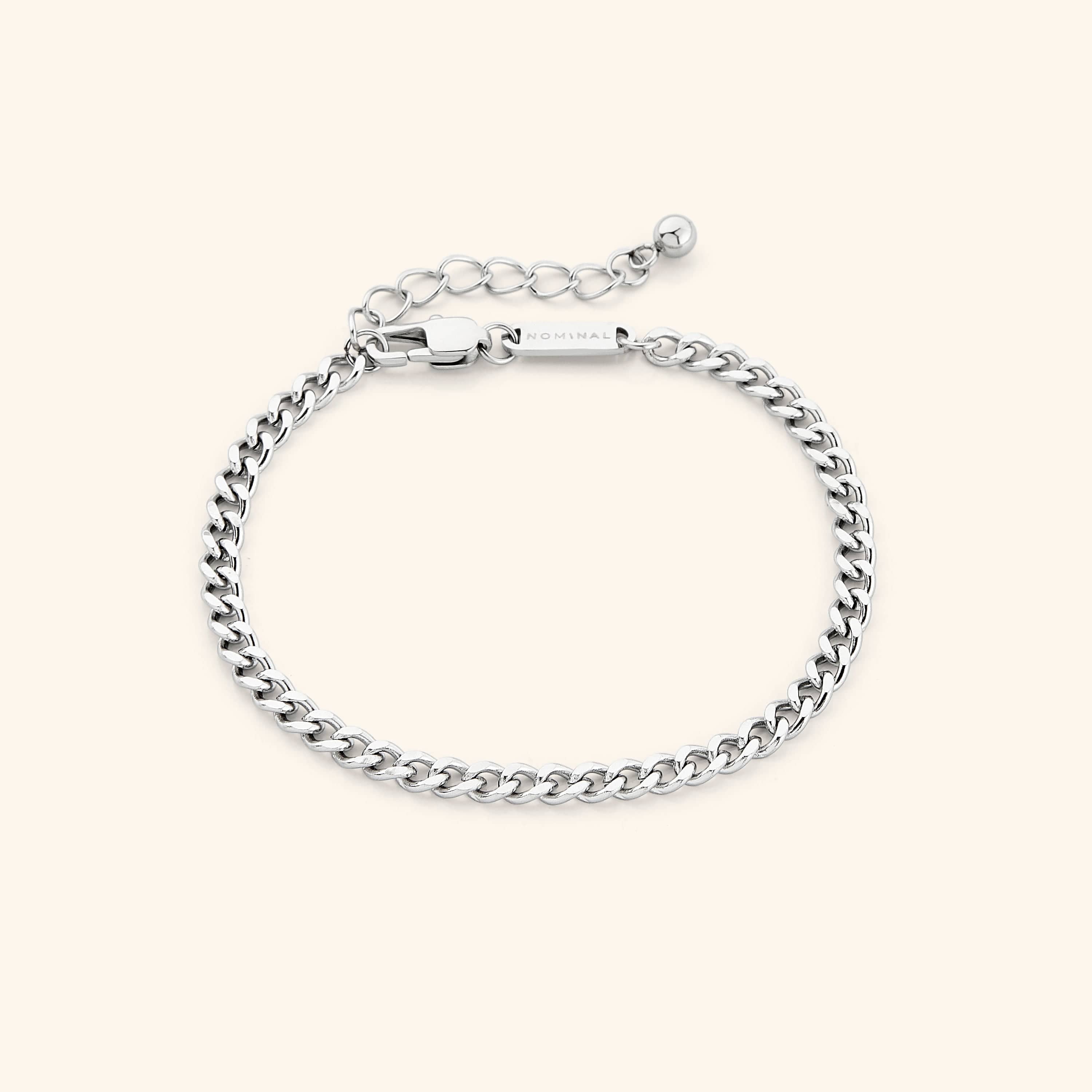 Worn gold curb chain bracelet on a womans wrist, highlighting its minimalist style.