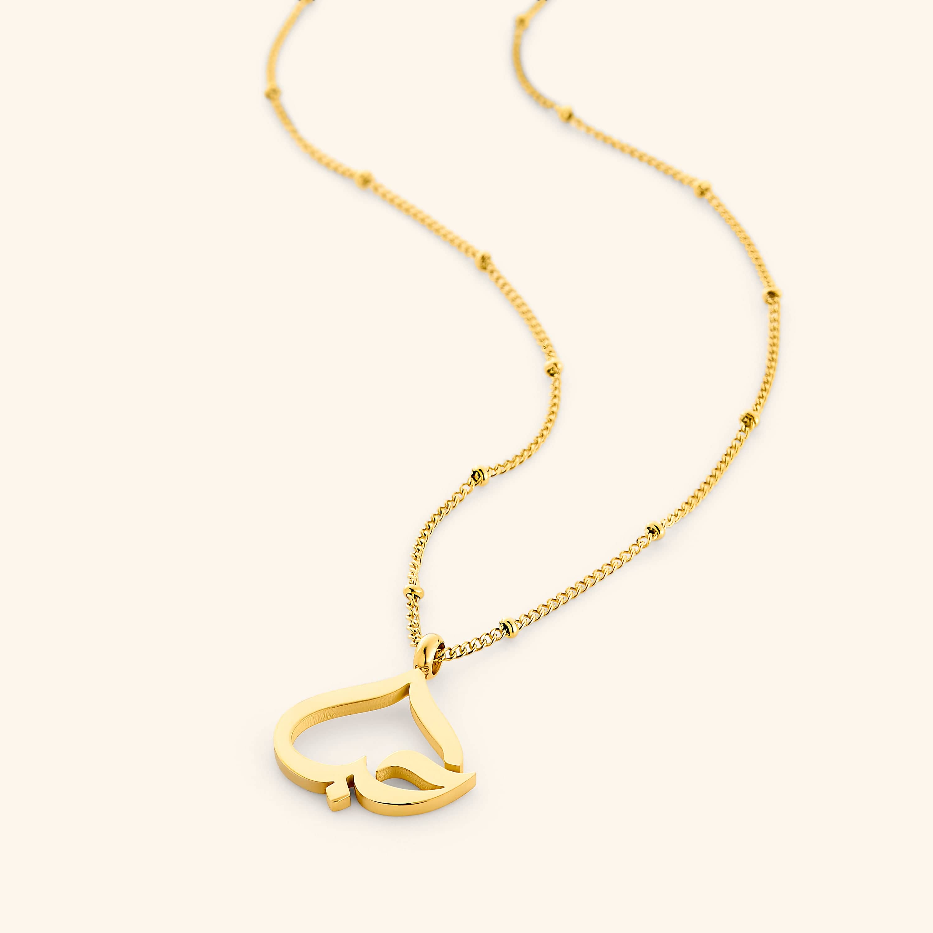Close-up of gold necklace with heart pendant featuring Arabic calligraphy, ideal for gifting