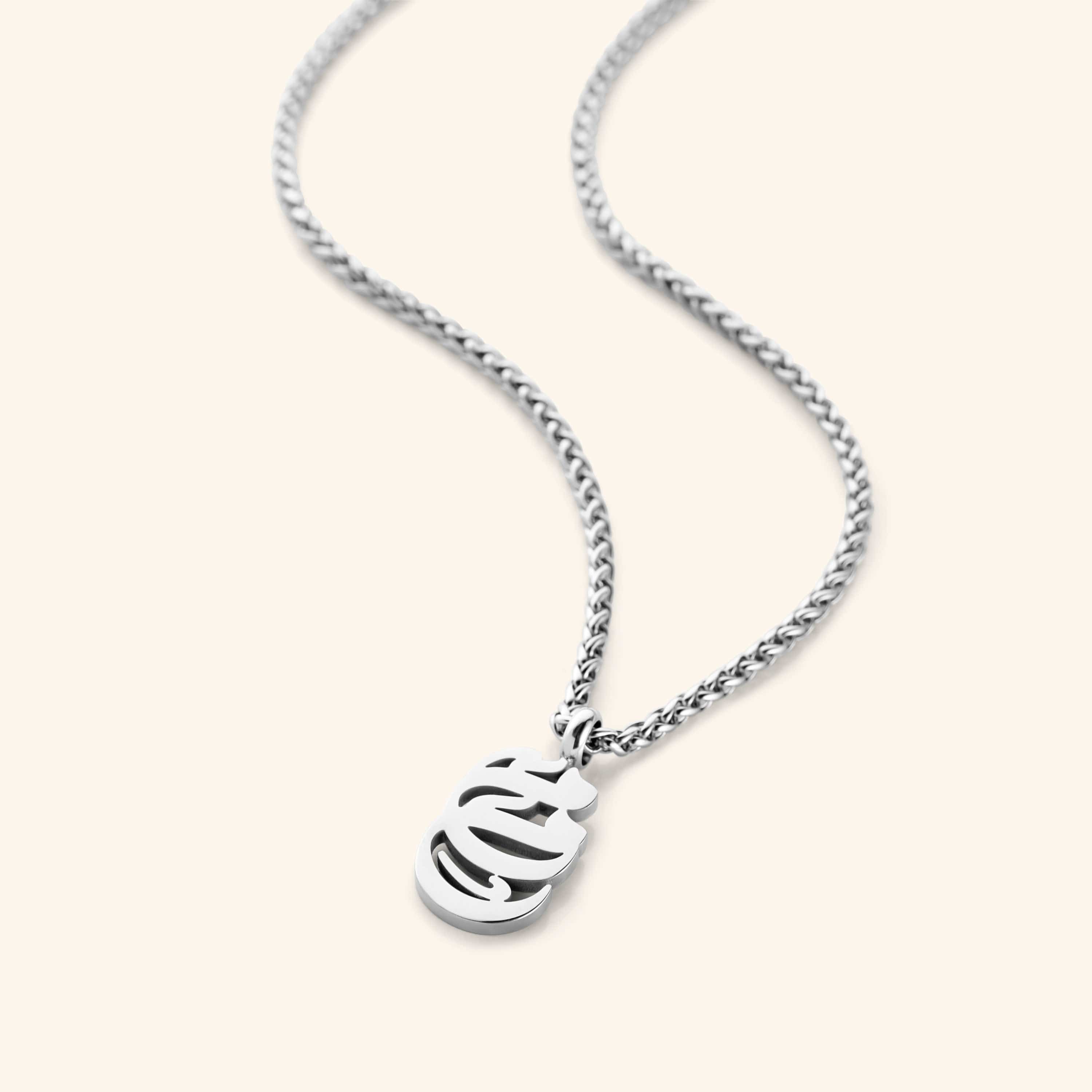 Close-up of the Mama Oval Necklace highlighting the intricate Arabic calligraphy.