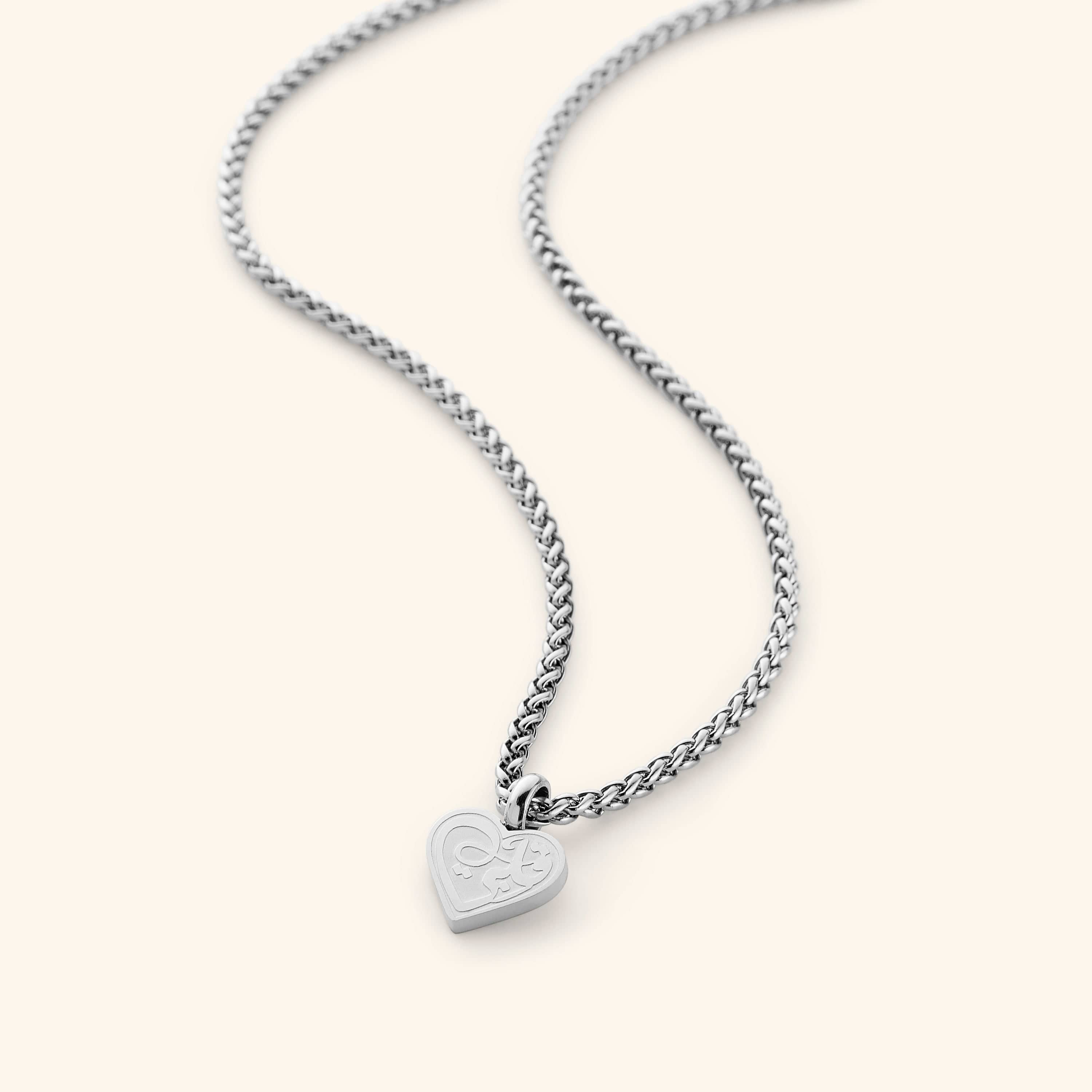 Mother and daughter wearing matching necklaces, showcasing their bond.