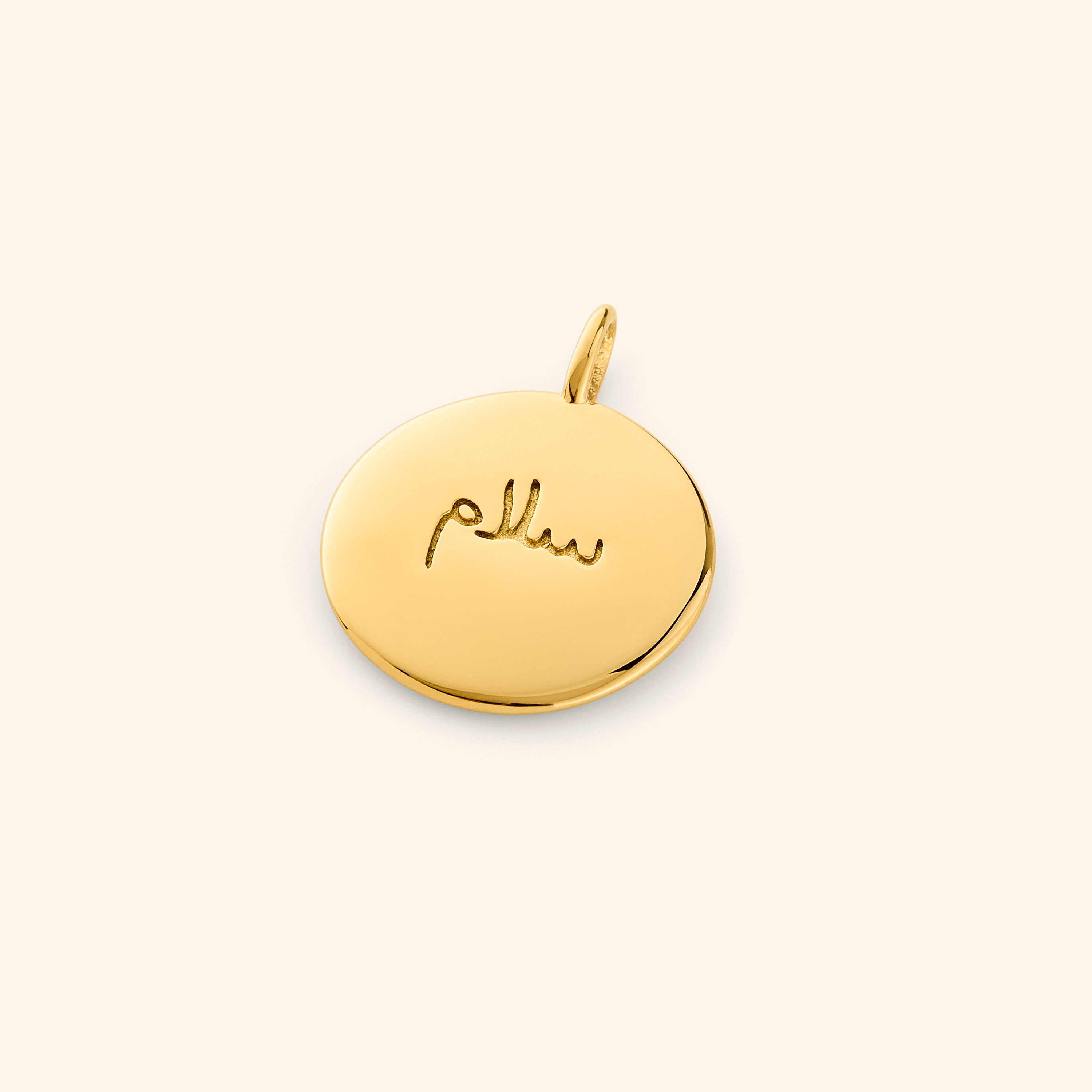 Serenity Gold Charm with Arabic engraving showing peace.