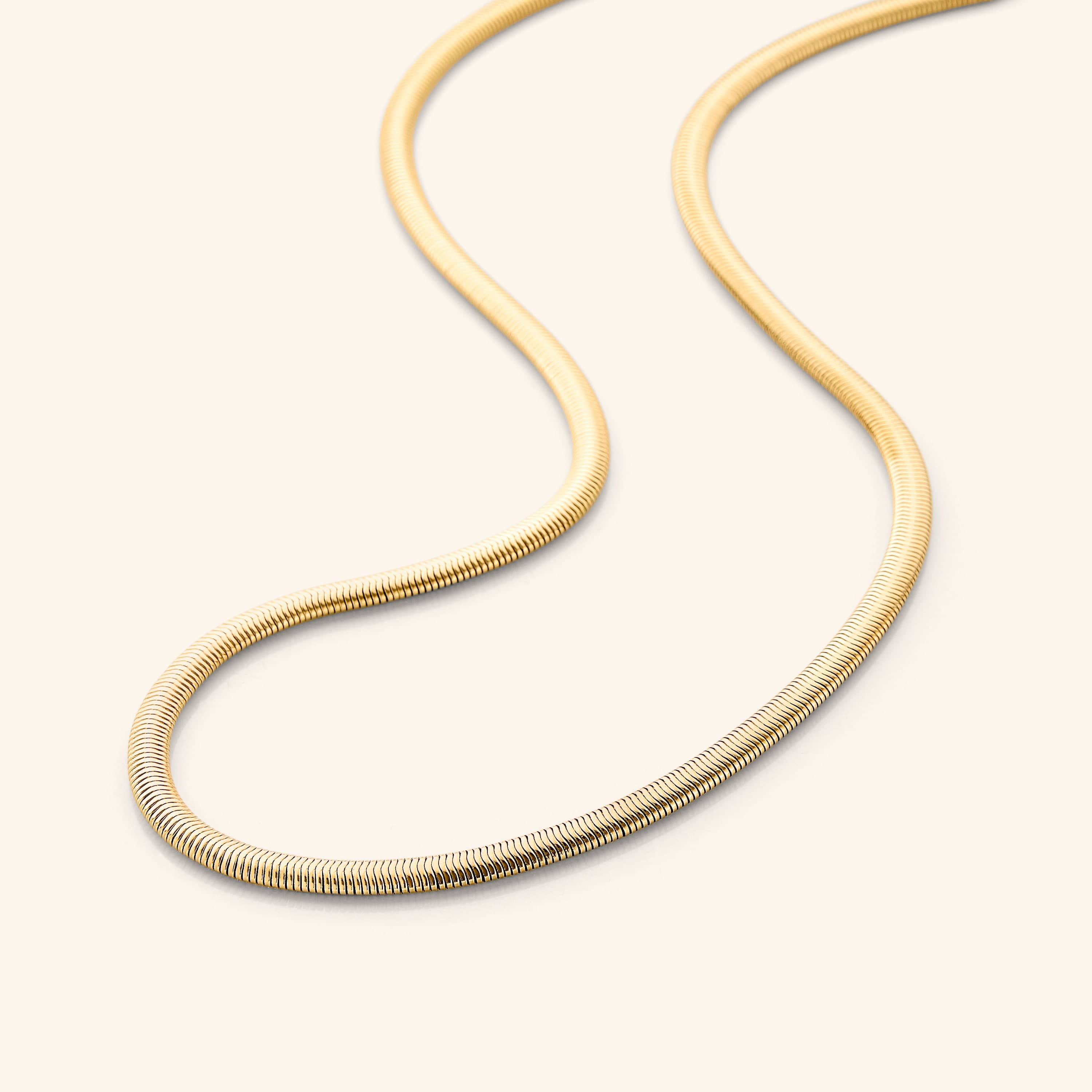 Close-up of elegant gold snake chain anklet showing its sleek design.