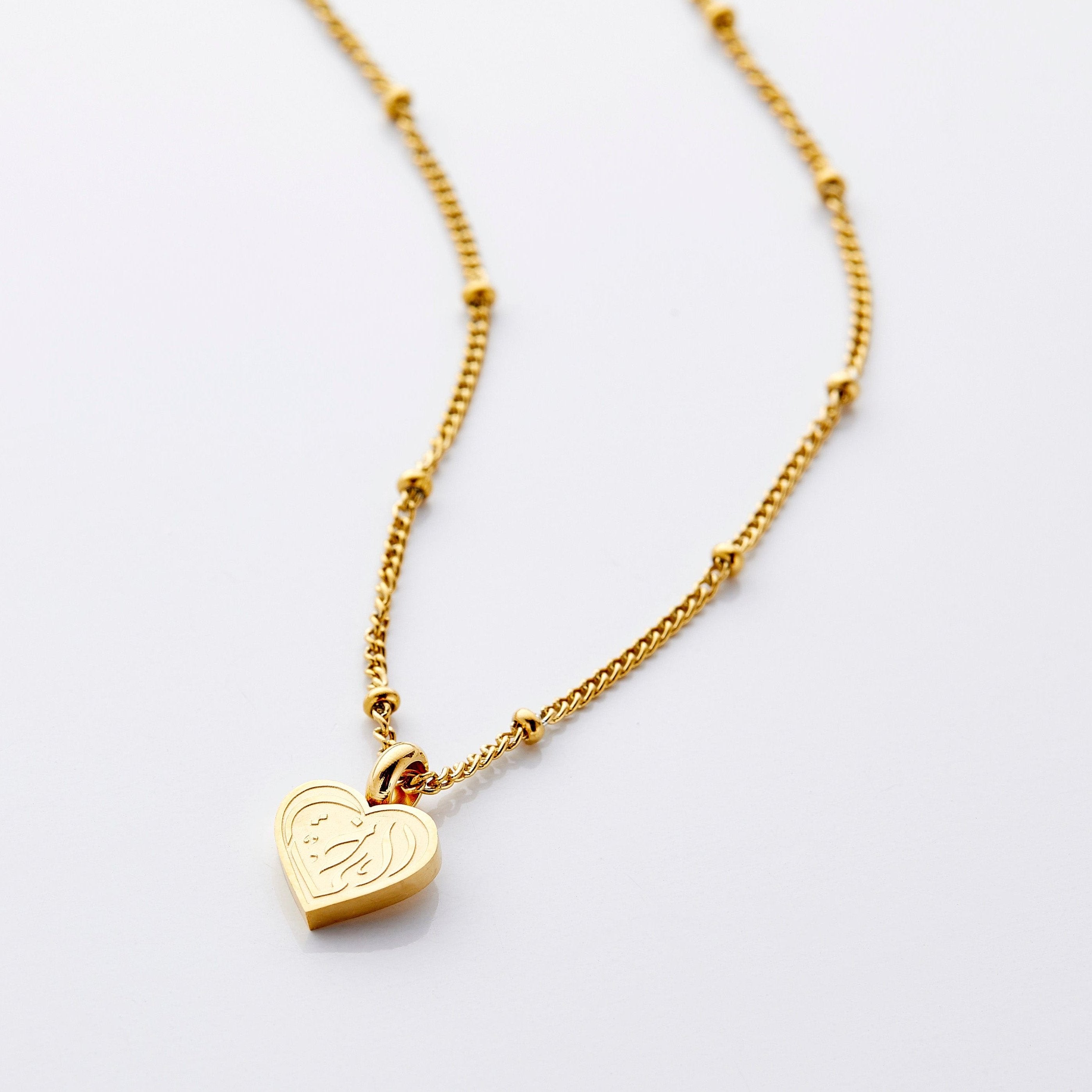 Close-up of sisterly love heart pendant necklace showcasing engraving in Arabic.