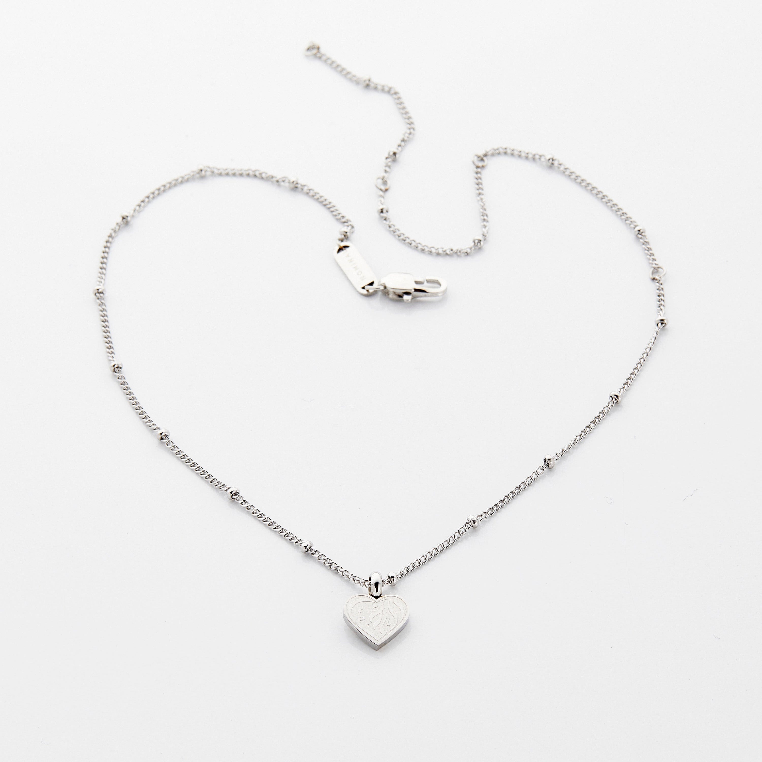 A young girl wearing the sister love necklace, smiling and showcasing her joy in celebrating sisterhood.