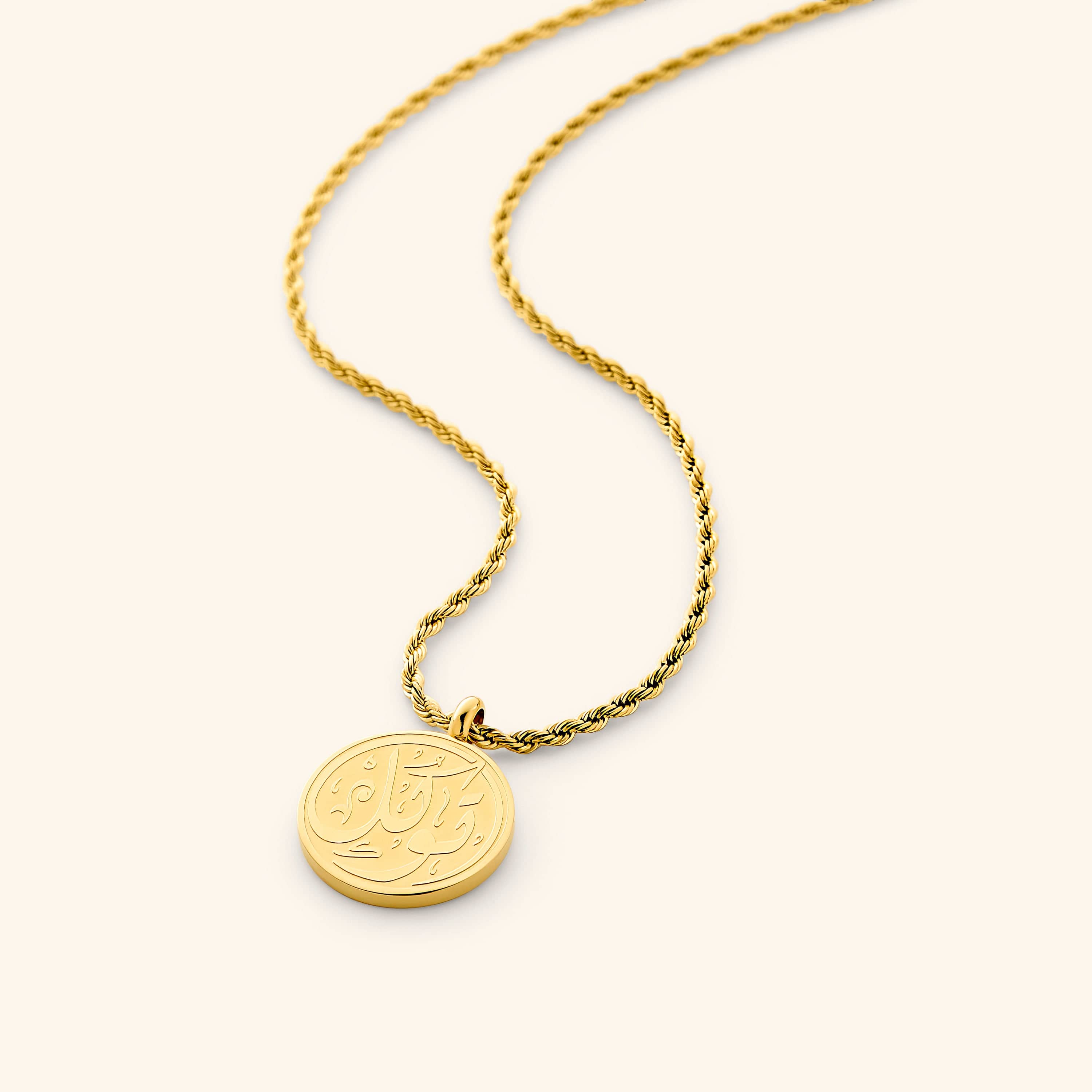 Trust Token Calligraphy Necklace displayed on a velvet pouch, highlighting its gold finish.