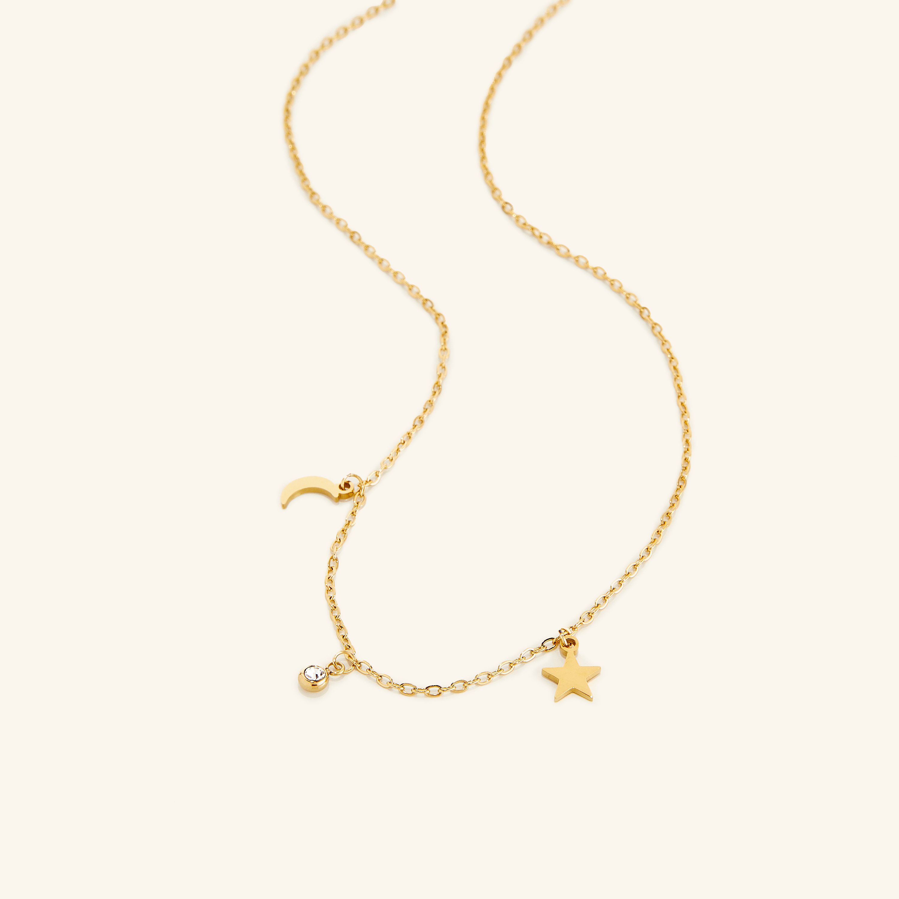 Close-up of the gold celestial necklace showcasing its moon pendant in natural light.