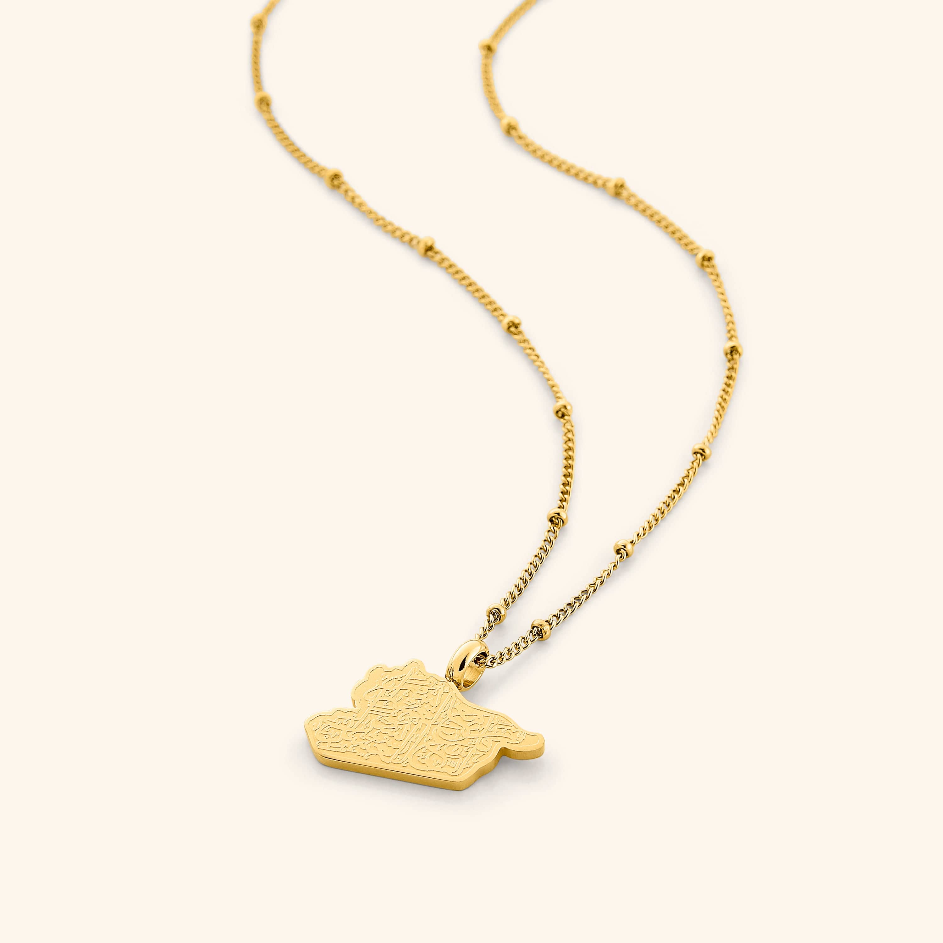 Close-up of Resilient Journey engraved gold necklace showing inscription