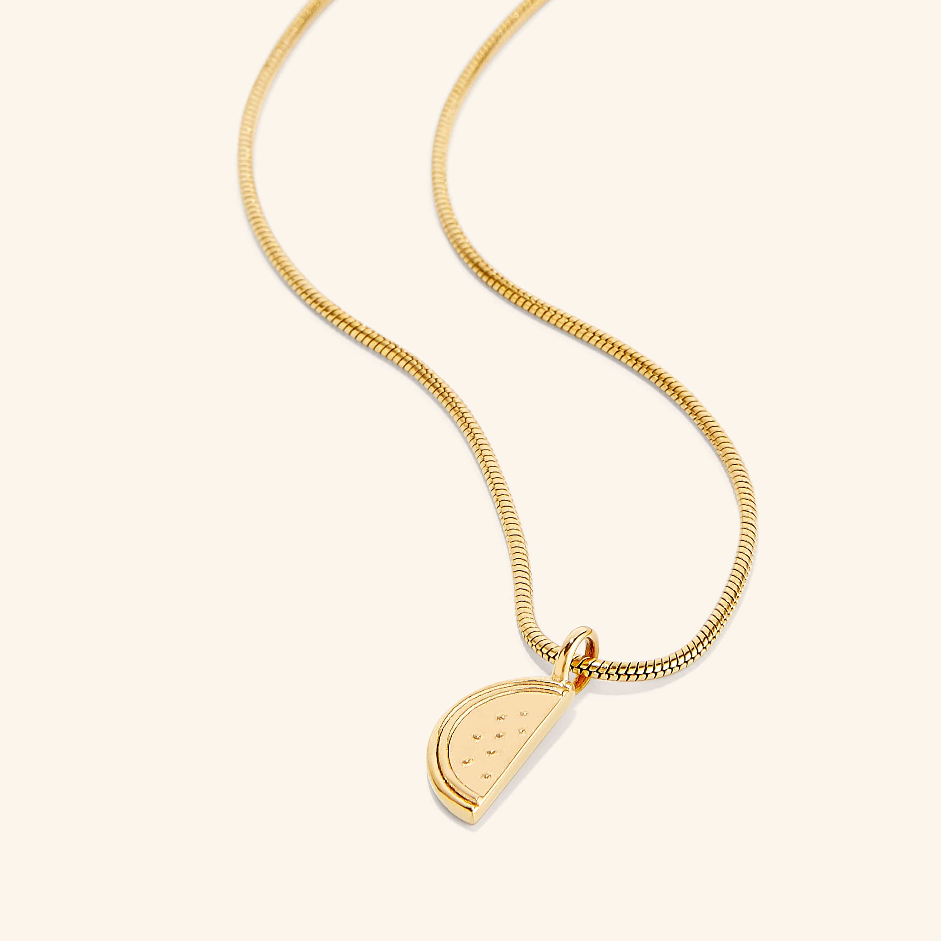 Close-up of the Palestinian watermelon necklace highlighting the intricate gold plating.