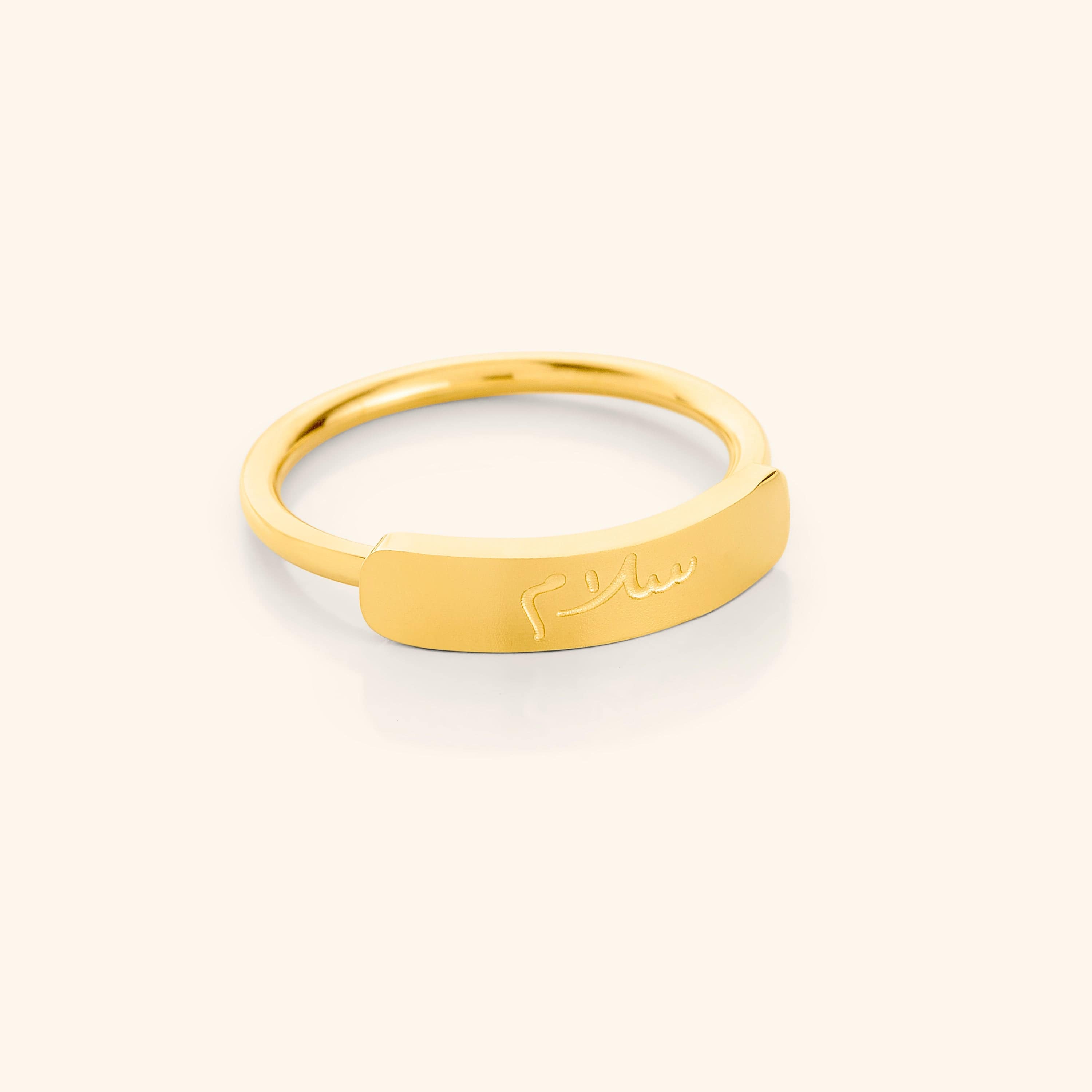 Elegant peace engraved bar ring on display, showcasing its minimalist design and gold finish.