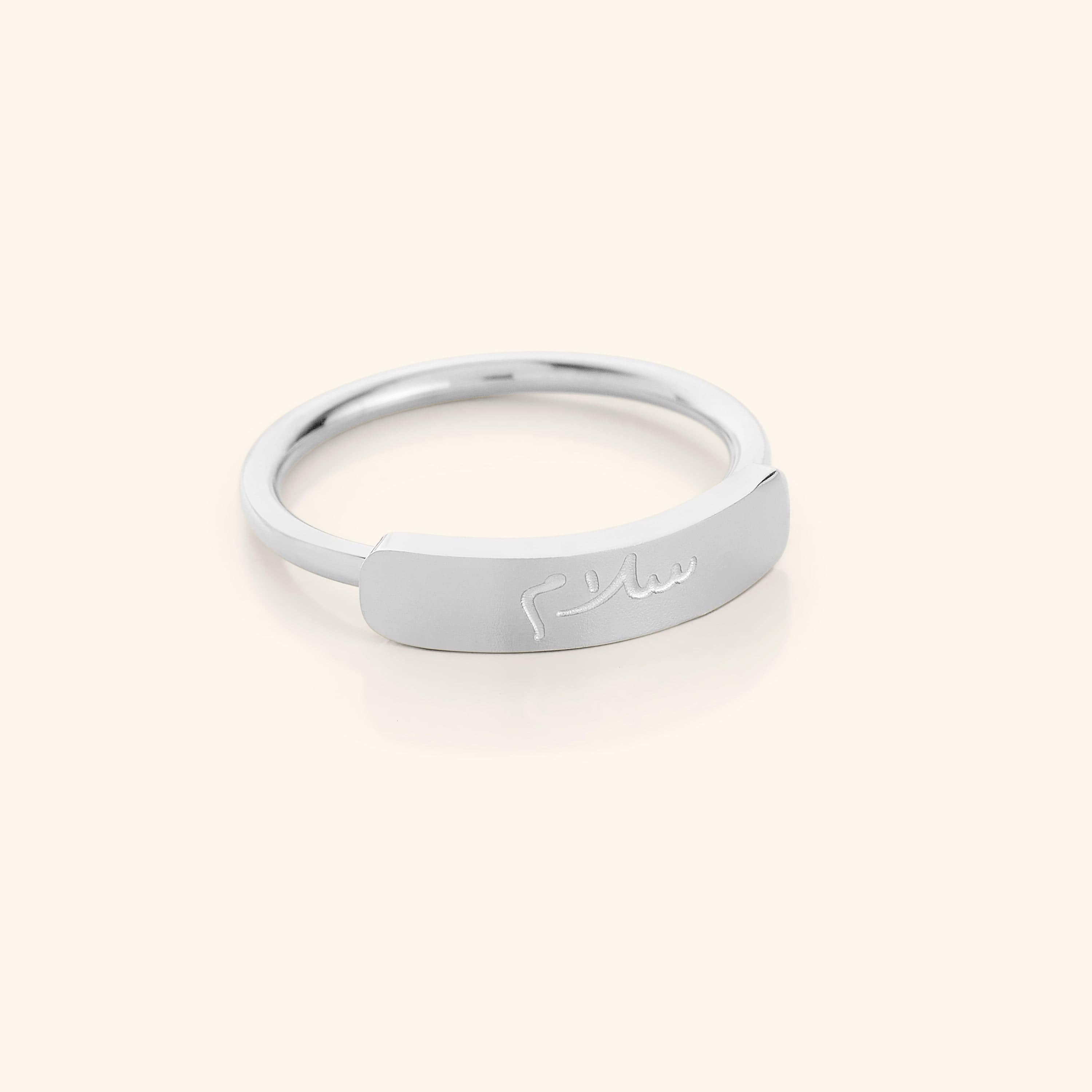 Elegant peace engraved bar ring on display, showcasing its minimalist design and gold finish.