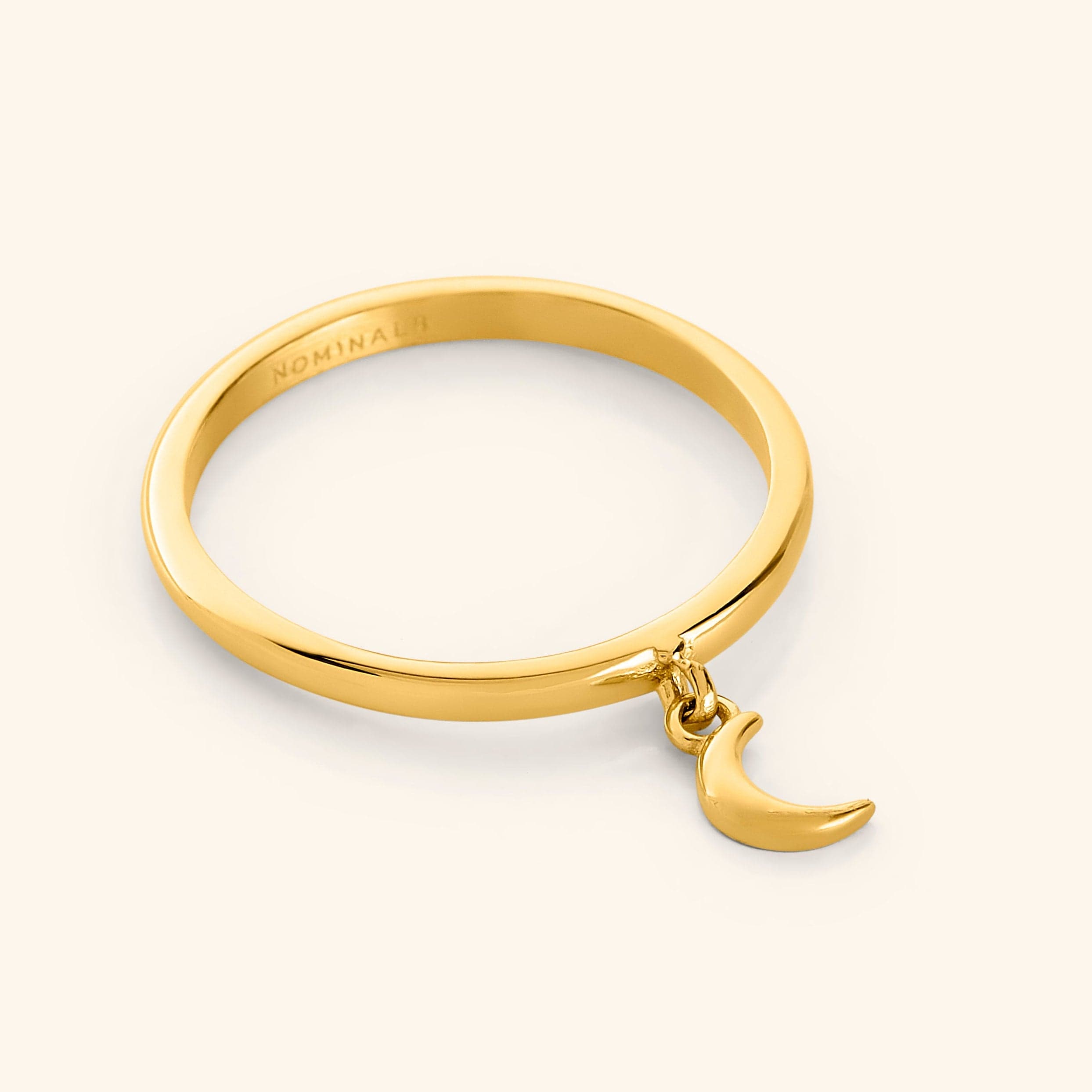 Close-up of crescent ring resting on velvet pouch, highlighting minimalist jewelry details