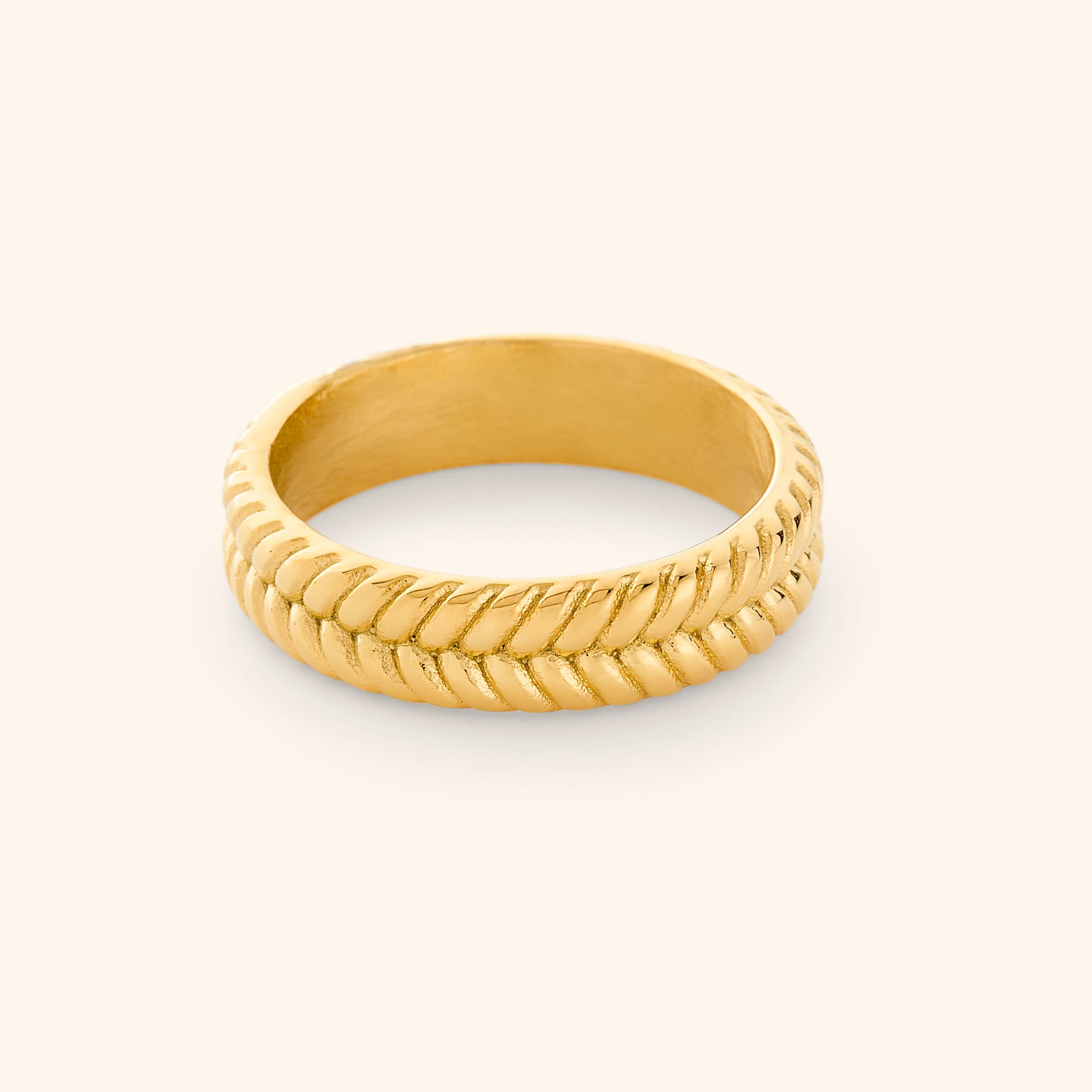Elegant herringbone gold ring displayed in a velvet pouch, emphasizing its delicate design.