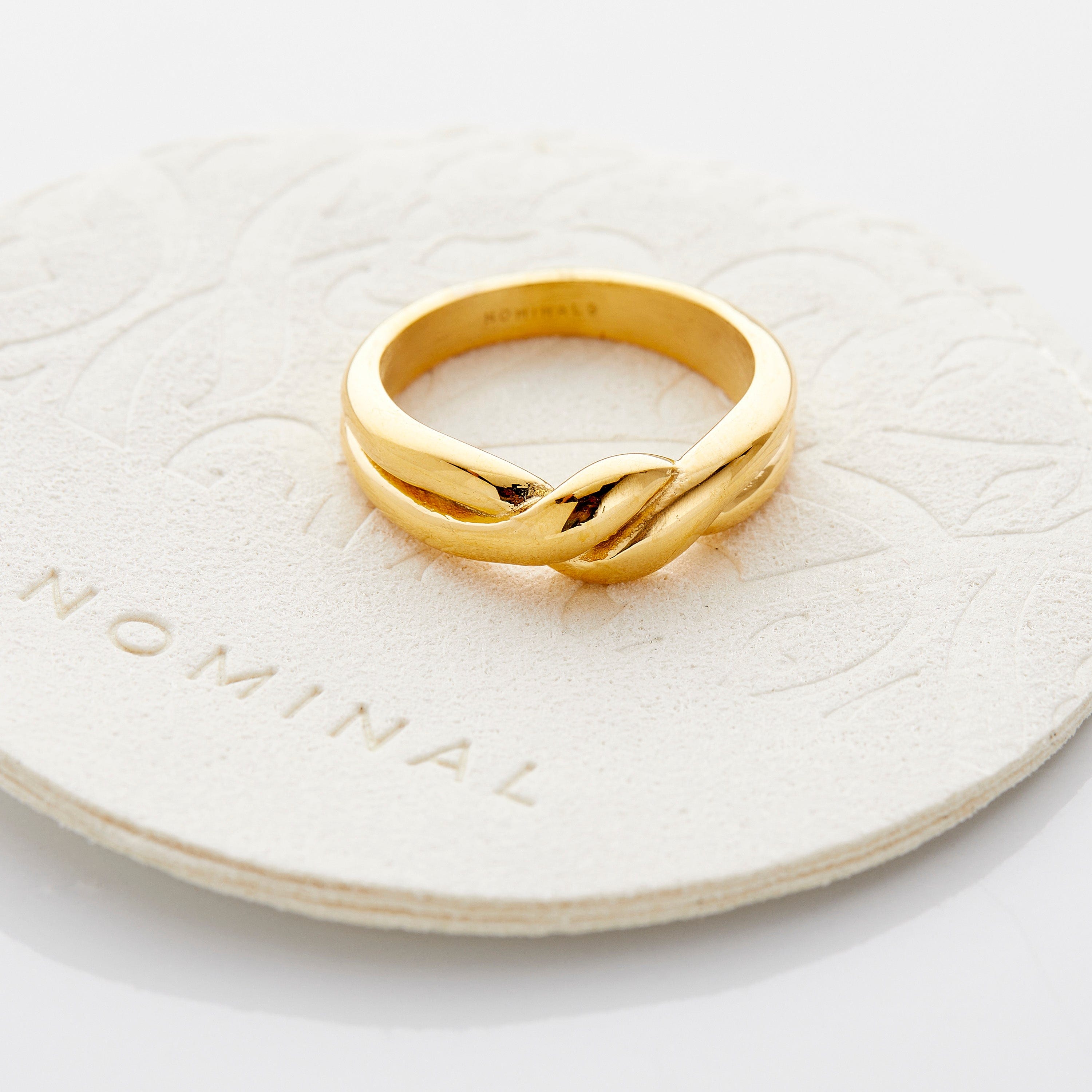 The knot ring displayed in a velvet pouch, emphasizing its elegant packaging.