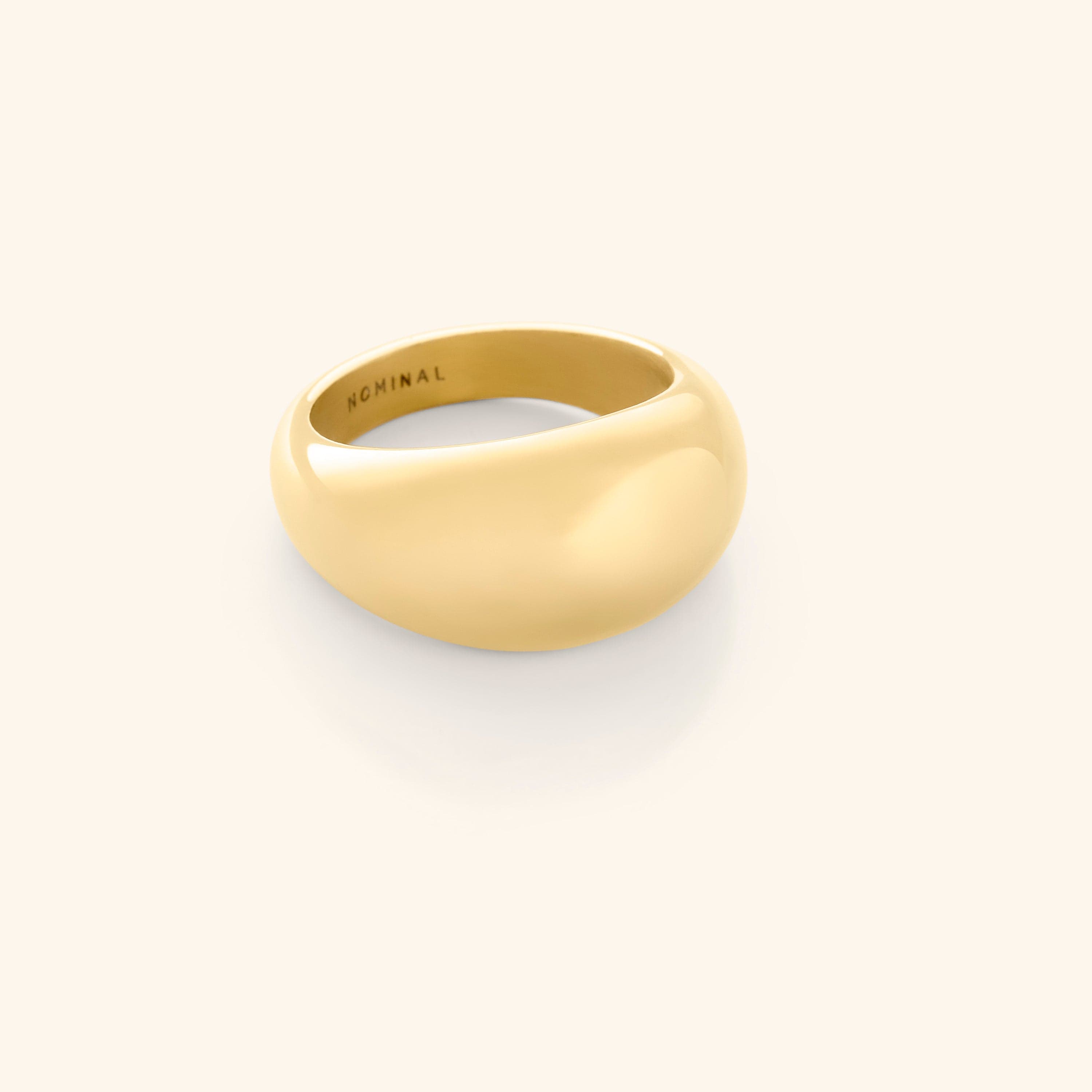Close-up of Domed Elegance Gold Ring highlighting its tapered design and shiny finish.