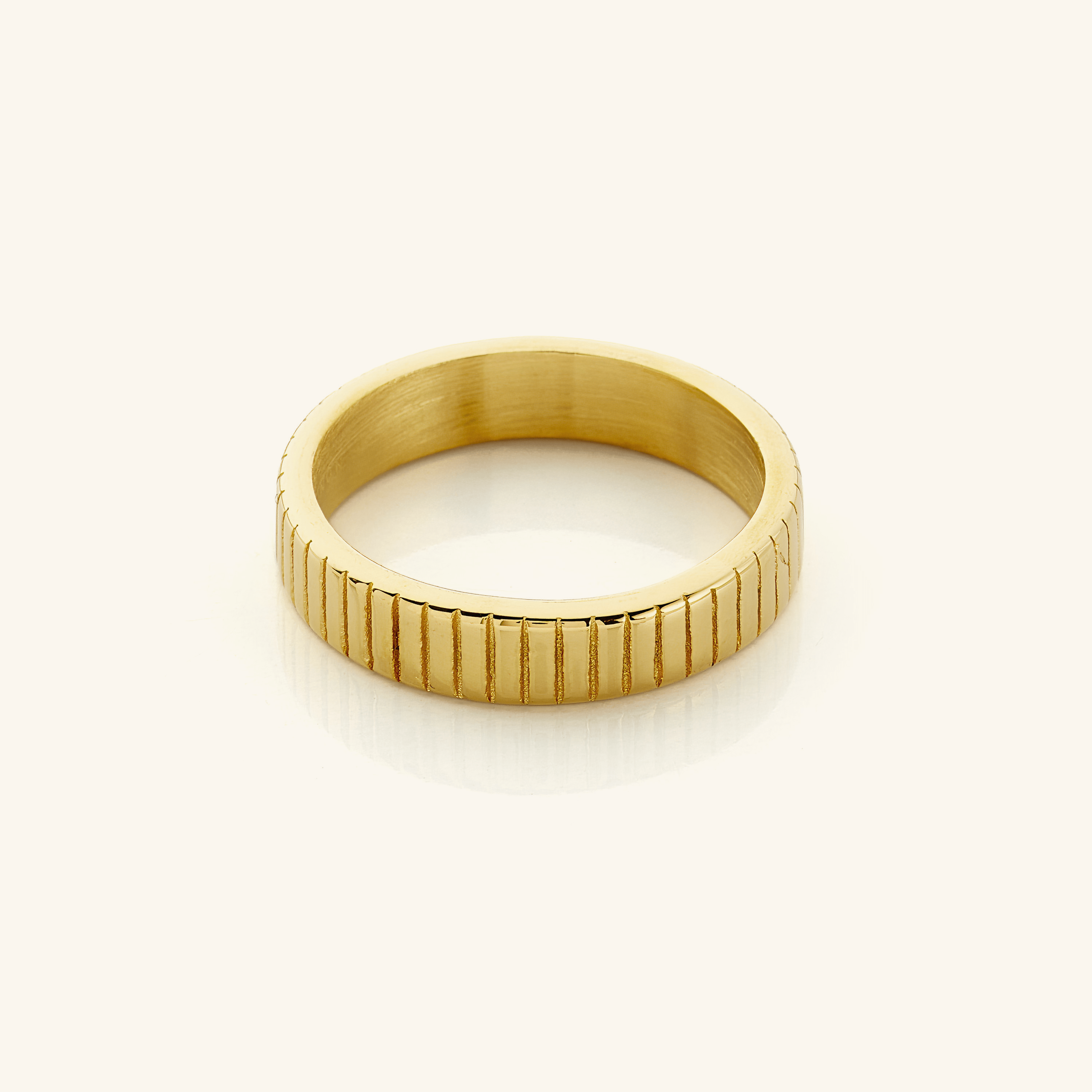 Velare™ Ridged Ring stacked with other gold rings on a model’s hand, showcasing depth and texture