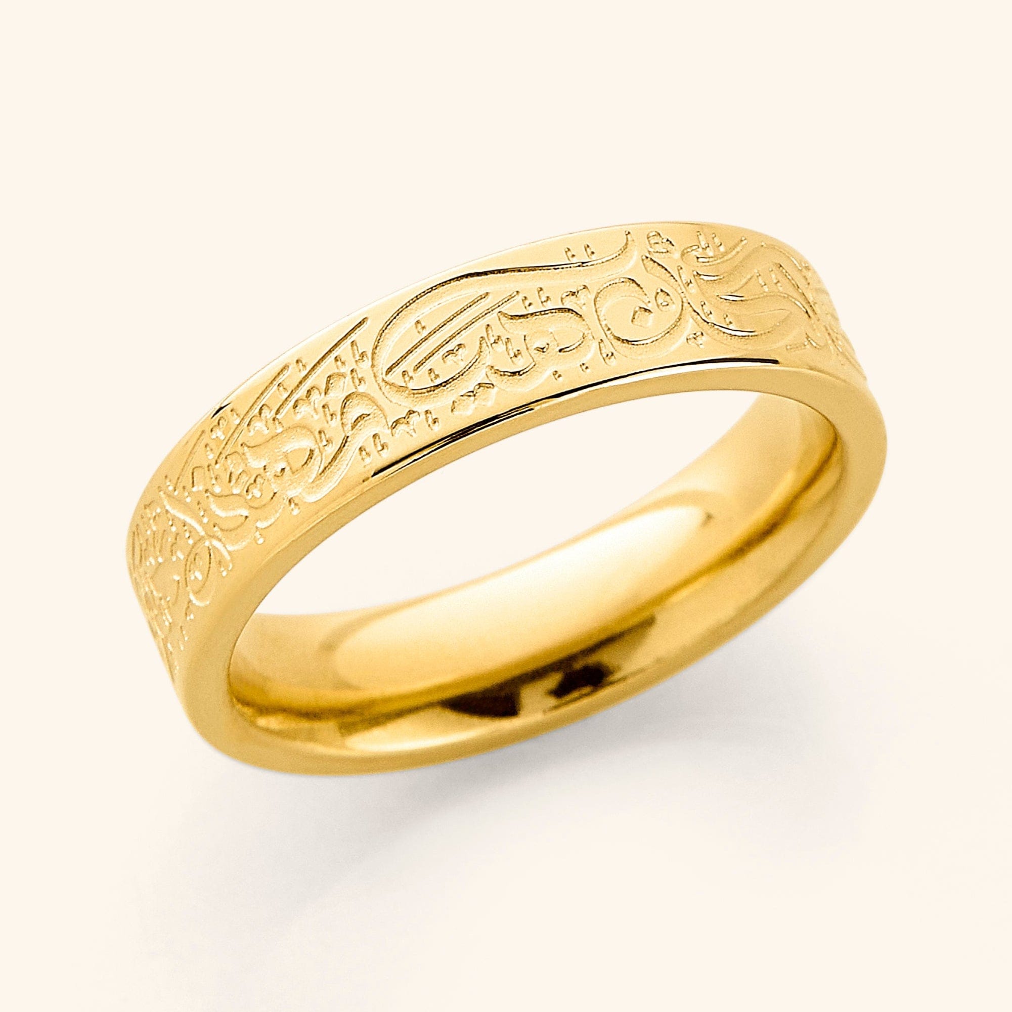 Close-up of the gold plated resilience ring with quote, showing detailed engraving on the outer band.