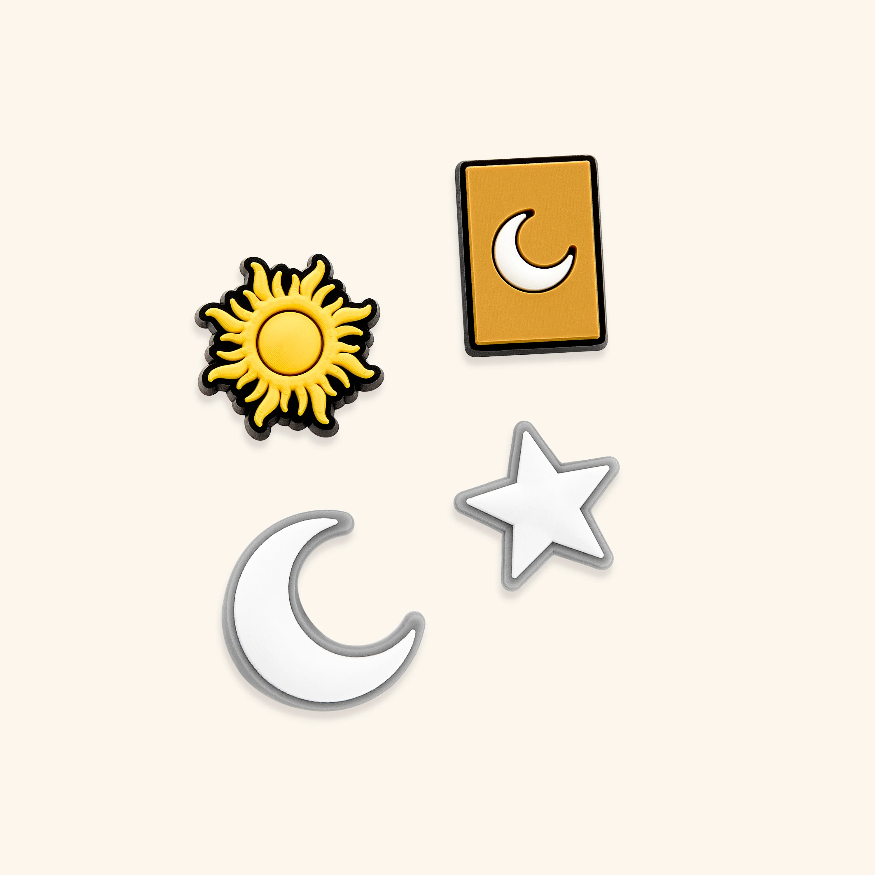 Close-up of the celestial charm pack for Crocs, showcasing the glowing crescent moon and radiant sun designs.