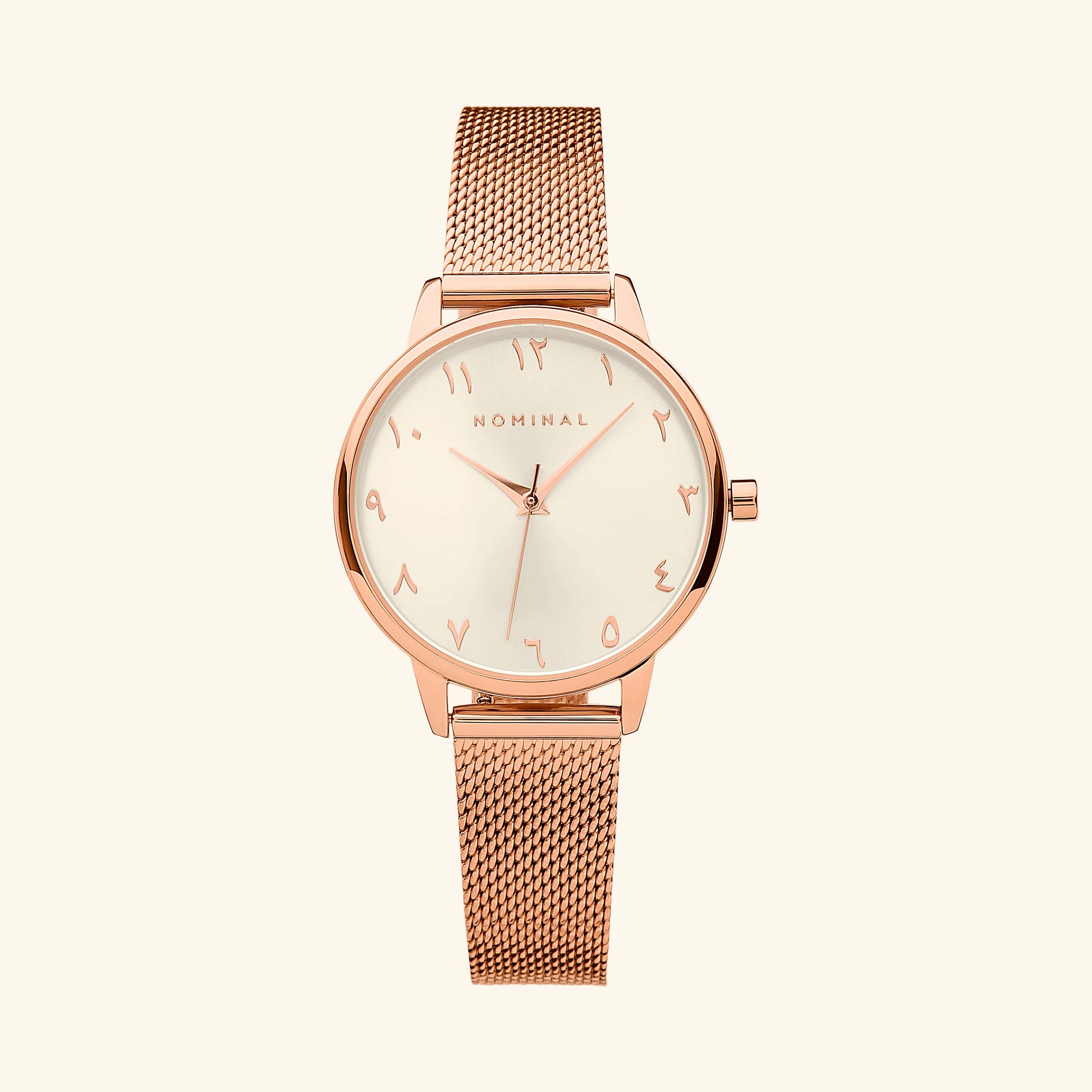 Close-up view of the radiant rose gold watch showcasing the Arabic numerals and white dial.