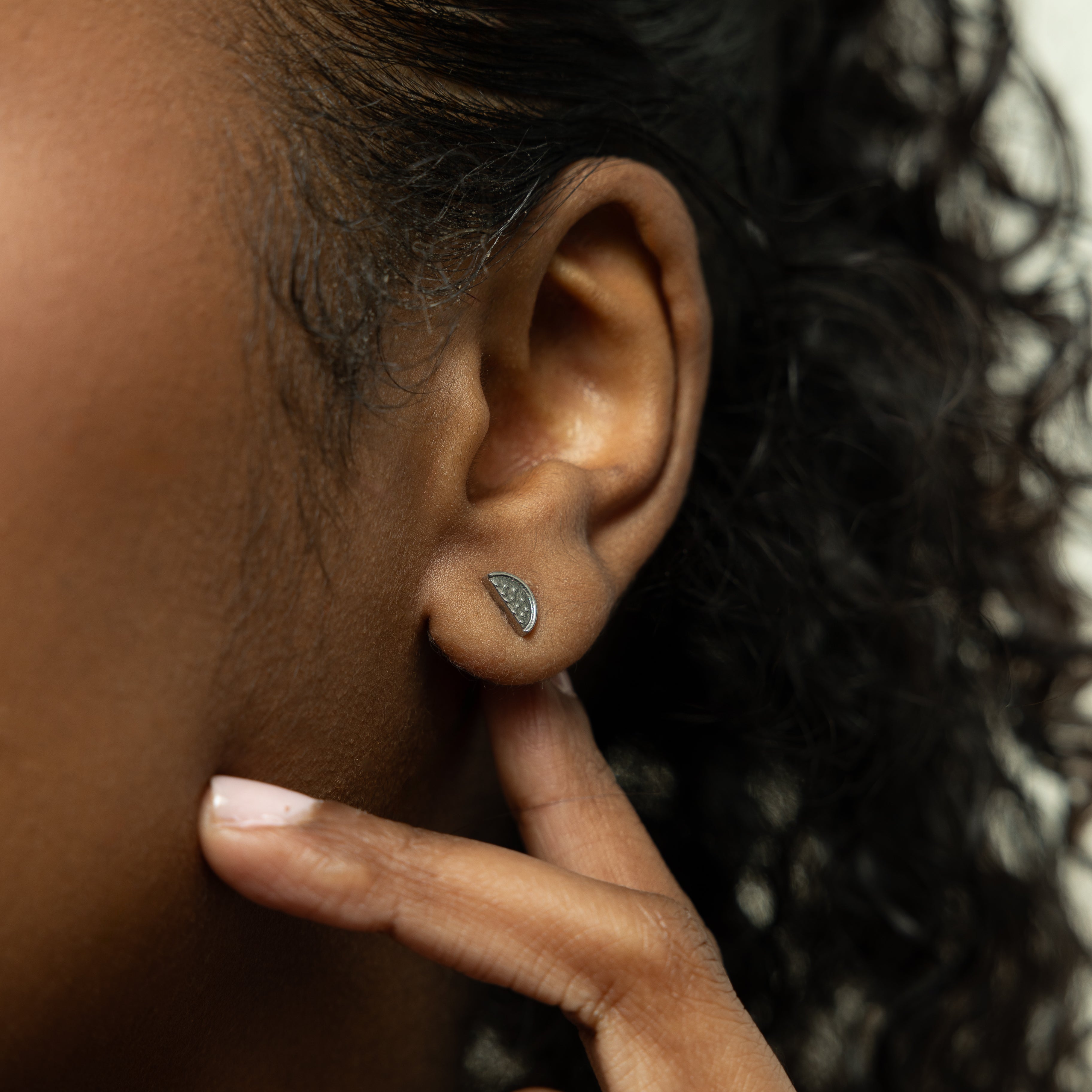 Close-up of vibrant watermelon studs showcasing their intricate design and gold plating.