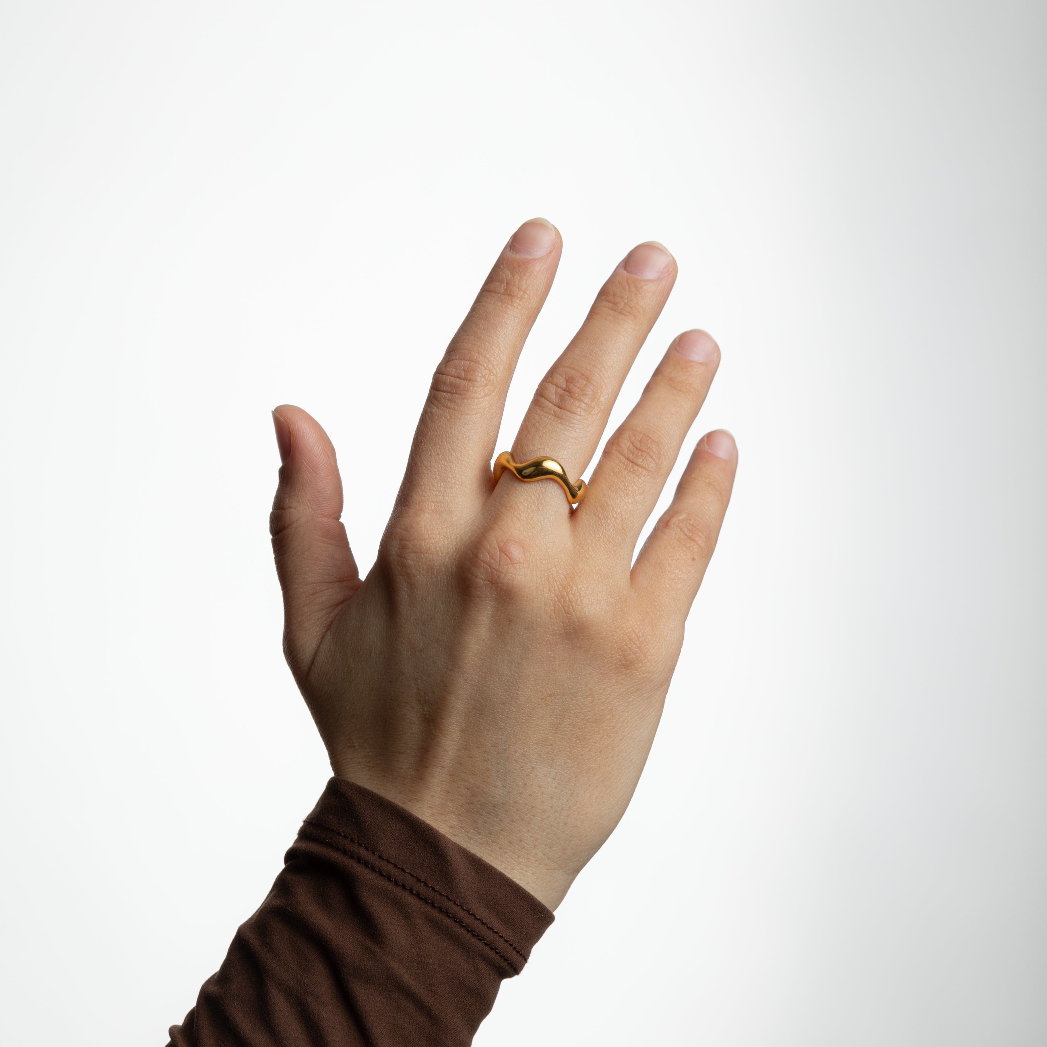 Oceanic Wave Gold Ring displayed in a velvet pouch, highlighting its elegant packaging.