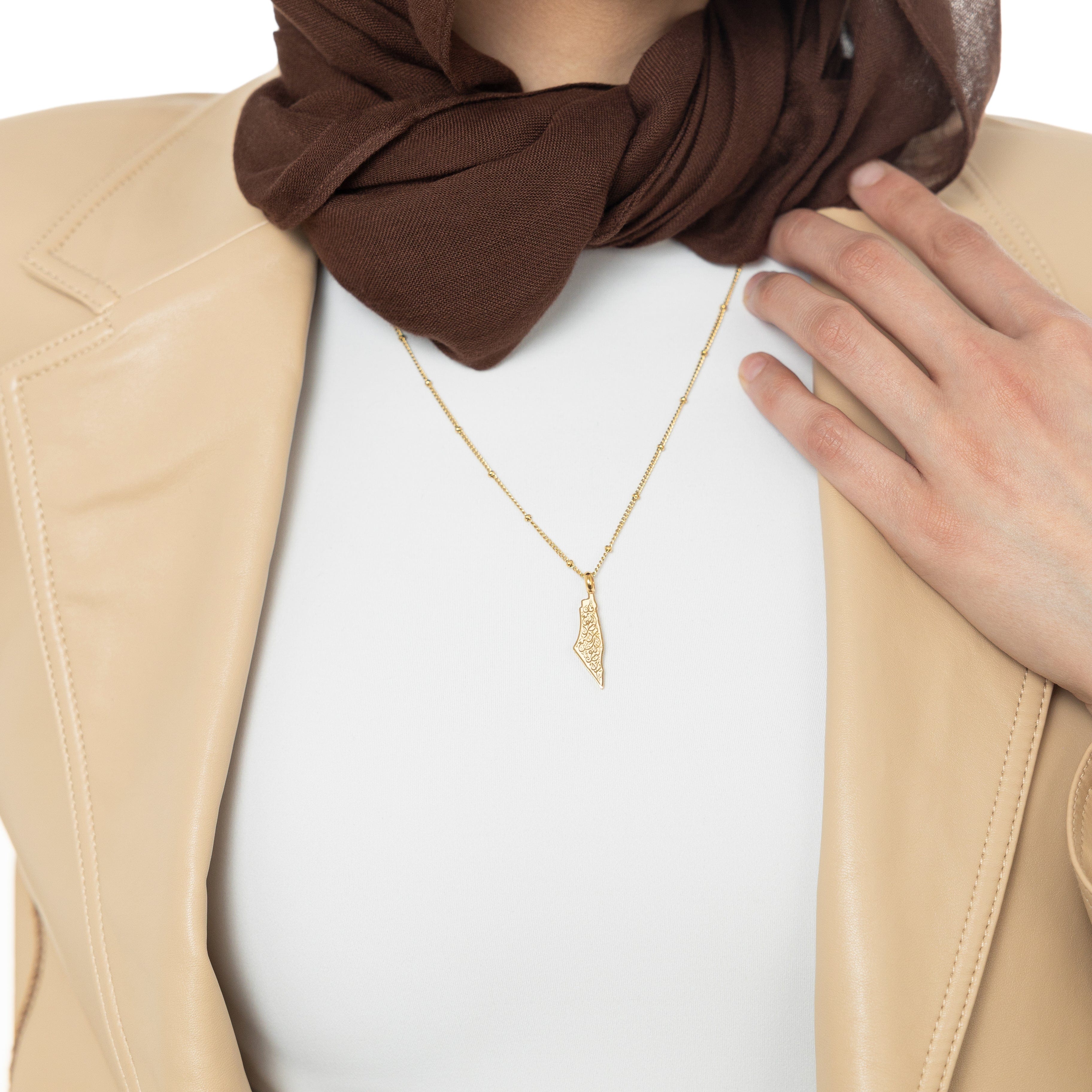 Close-up of Resilient Journey engraved gold necklace showing inscription