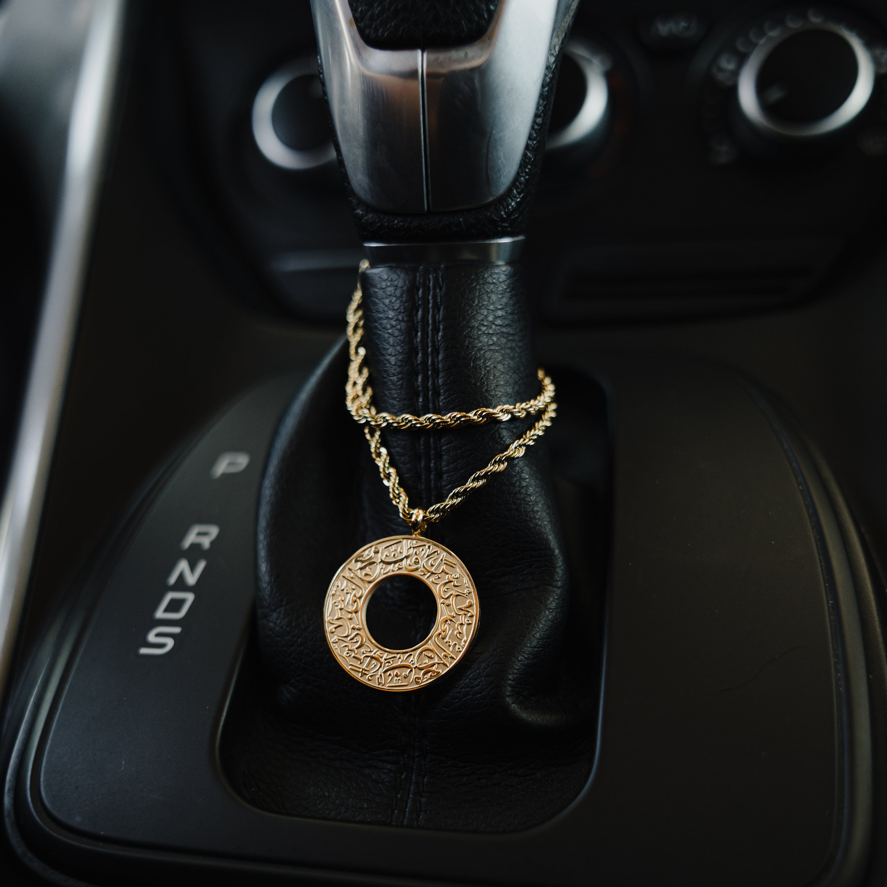 Close-up of the stainless steel car hanger, showcasing its craftsmanship and motivational design.
