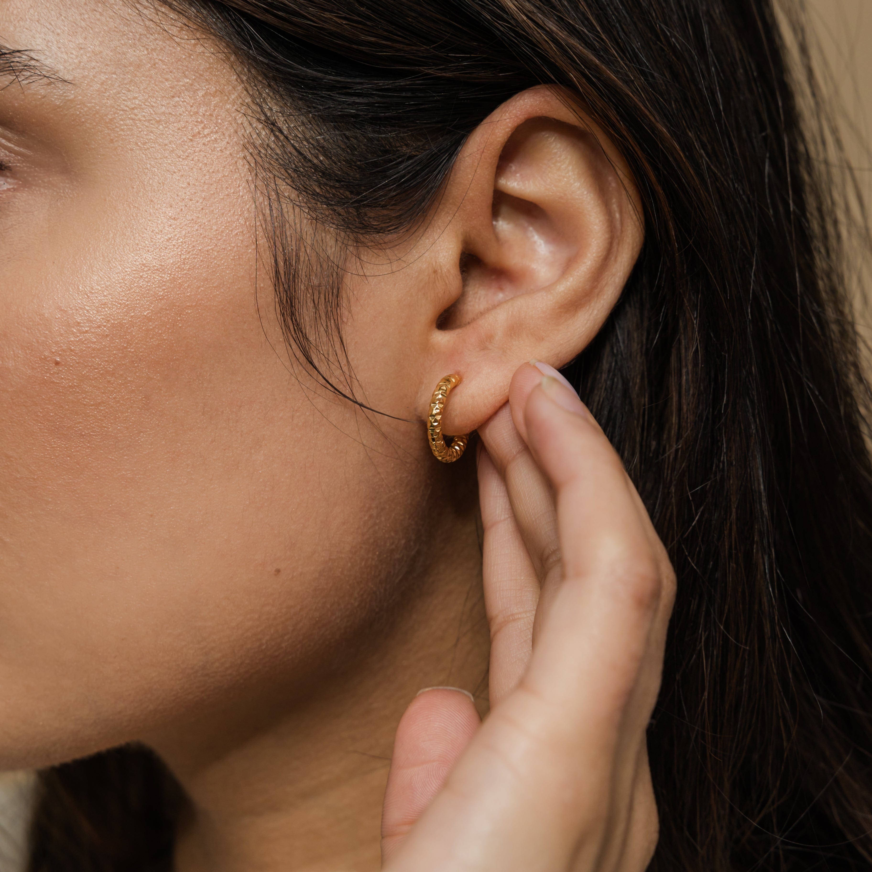 Mini gold hoop earrings for sensitive ears, showcasing the unique imperfect edges.
