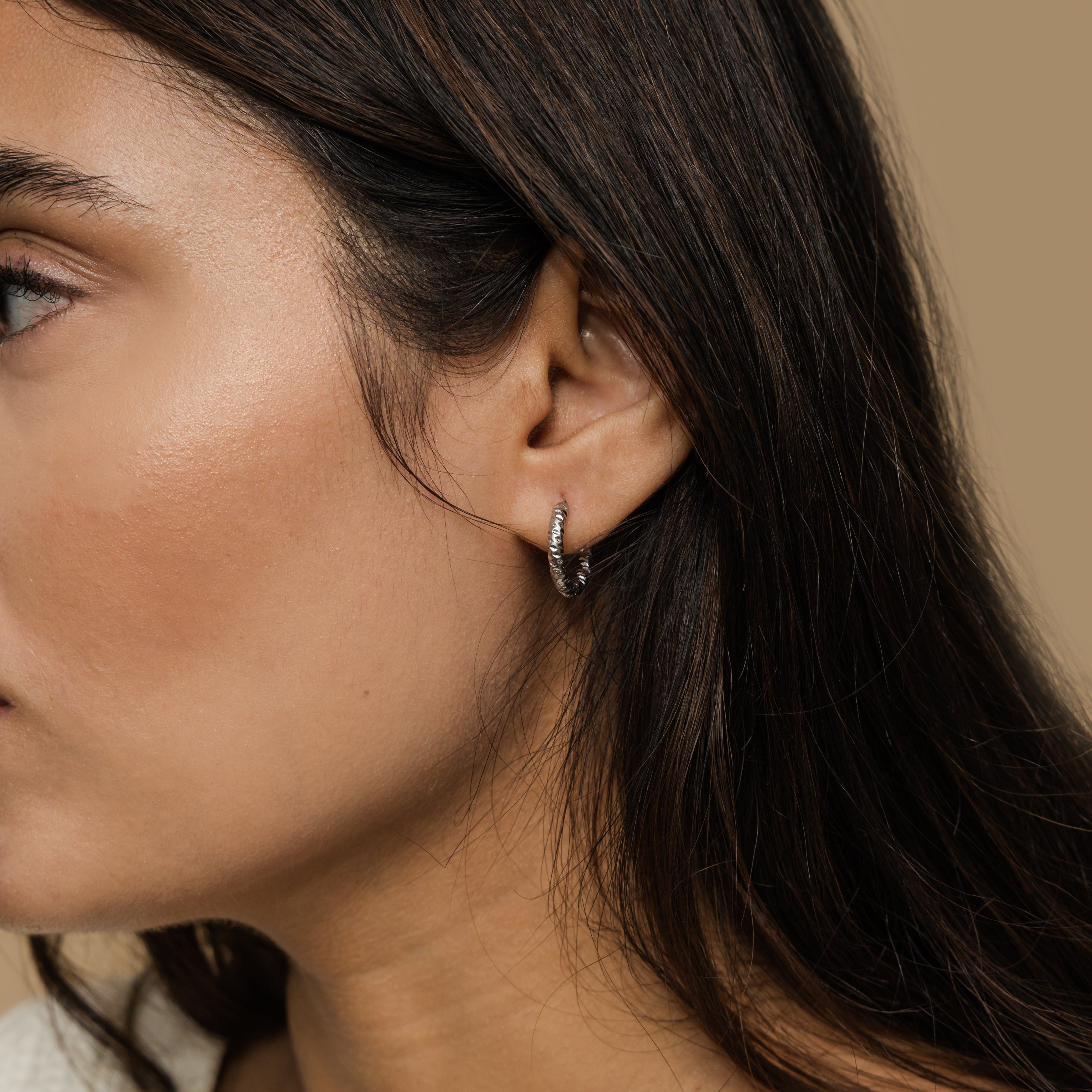 Close-up of waterproof hoop earrings, emphasizing the shiny gold finish.