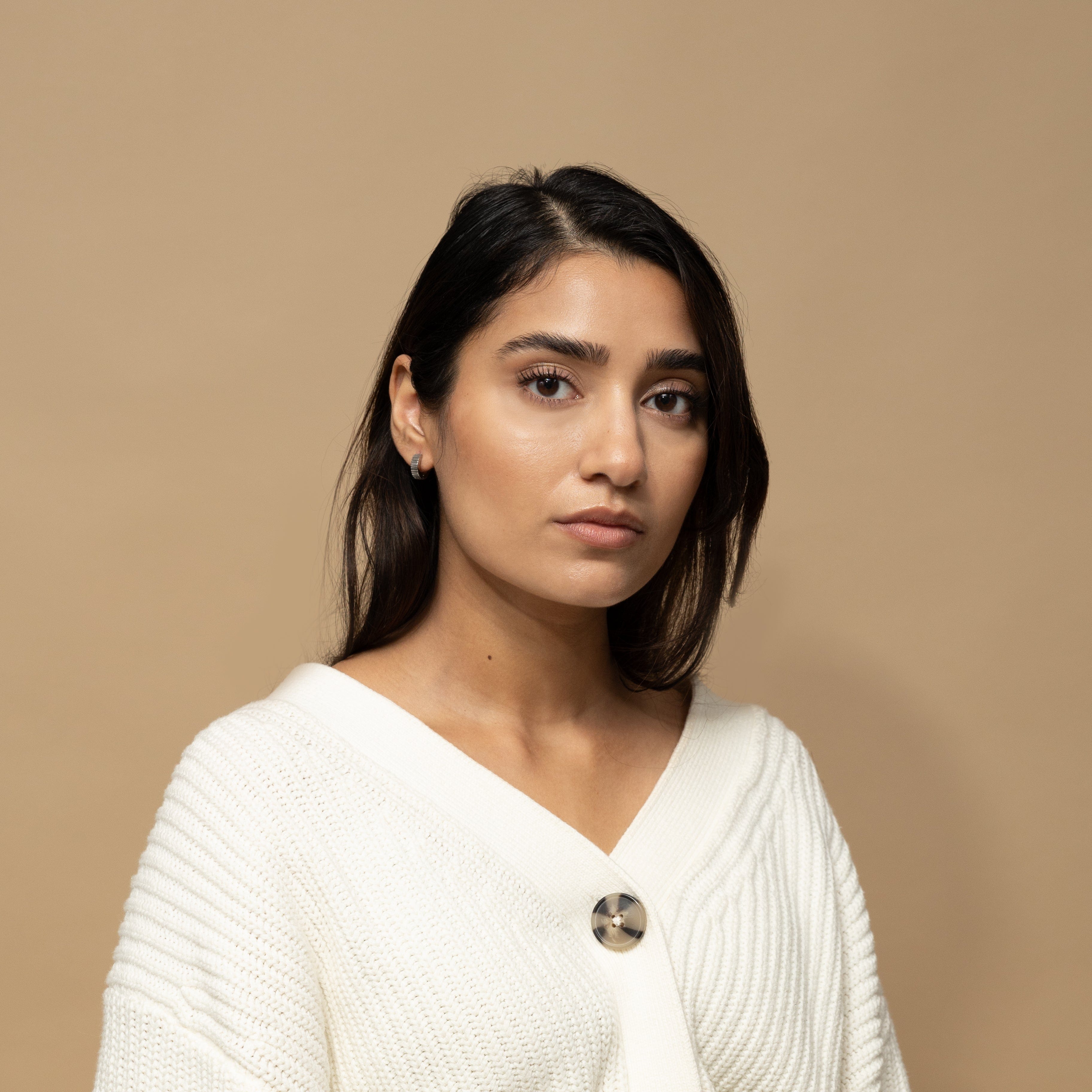 Elegant gold hoop earrings displayed in a velvet pouch, ideal for gifting.
