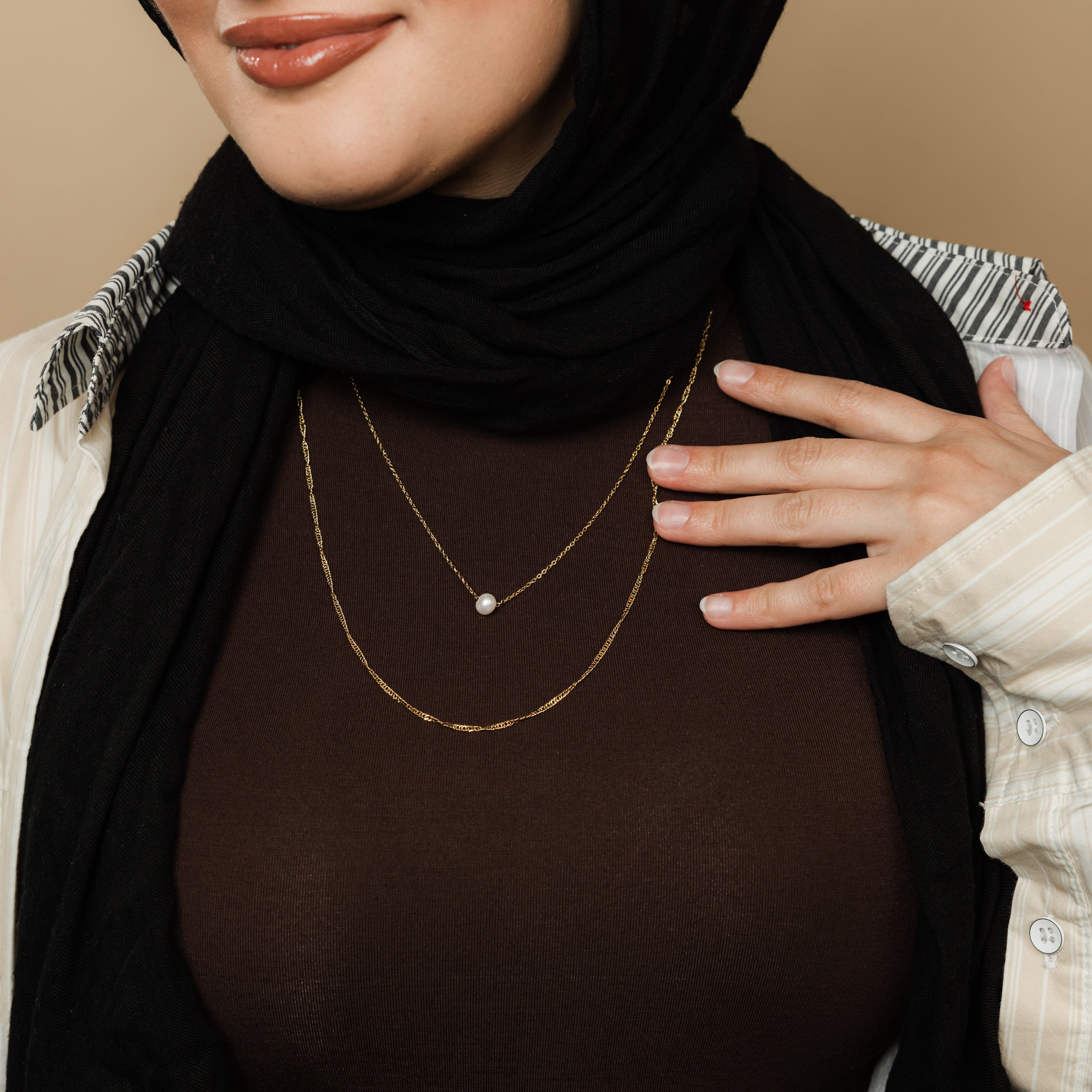Close-up of the twisted gold chain from the layered pearl necklace set, highlighting its shine and adjustable features.
