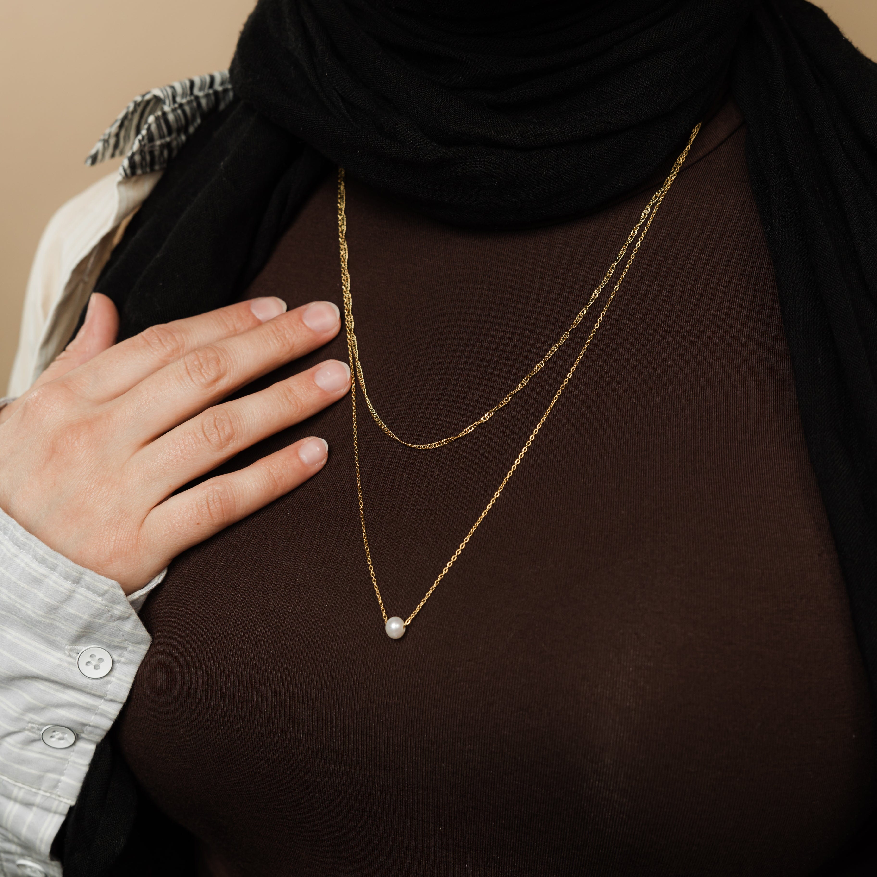 Close-up of the twisted gold chain from the layered pearl necklace set, highlighting its shine and adjustable features.