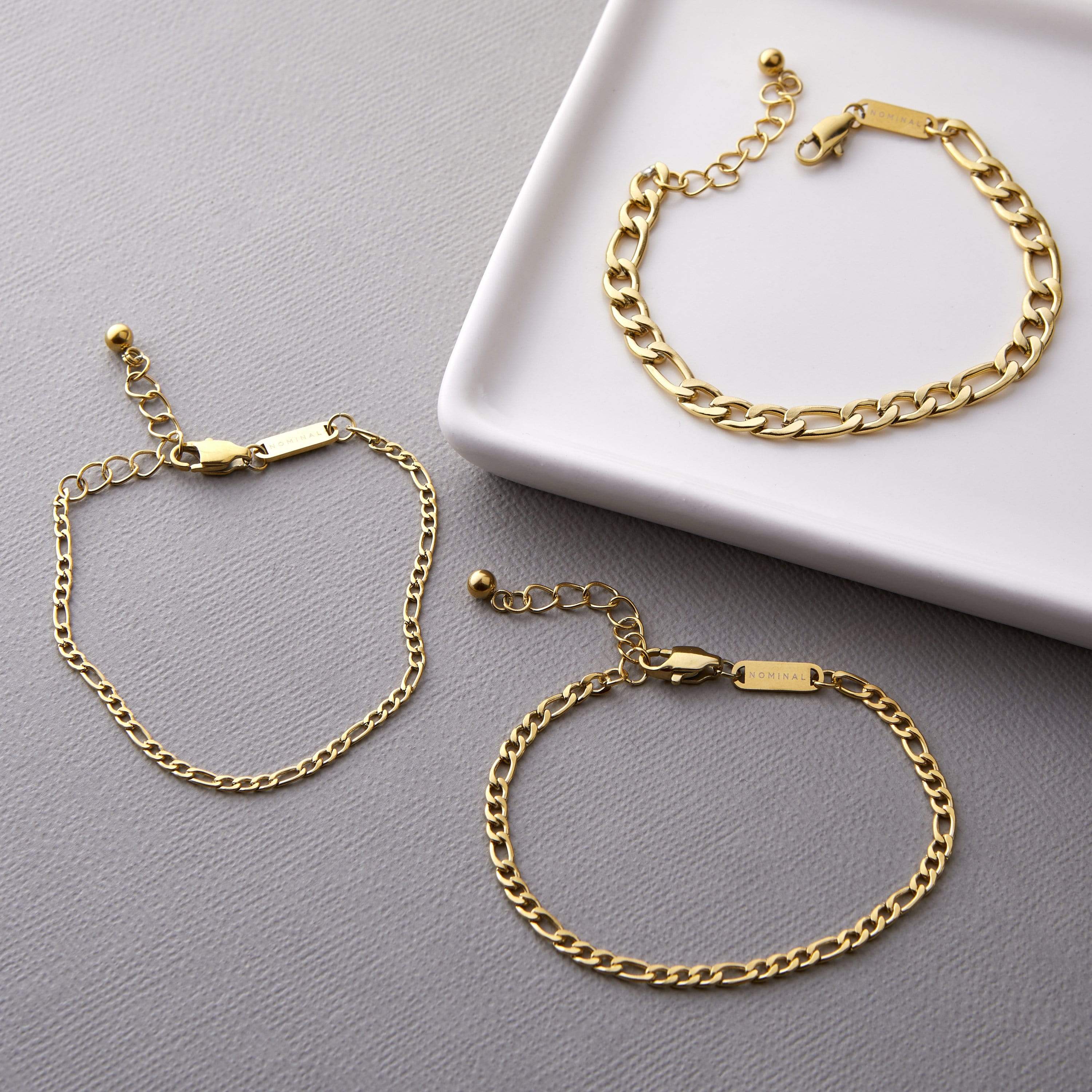 Close-up of the 5mm gold Figaro chain bracelet worn on a wrist, showcasing its shine and elegance.