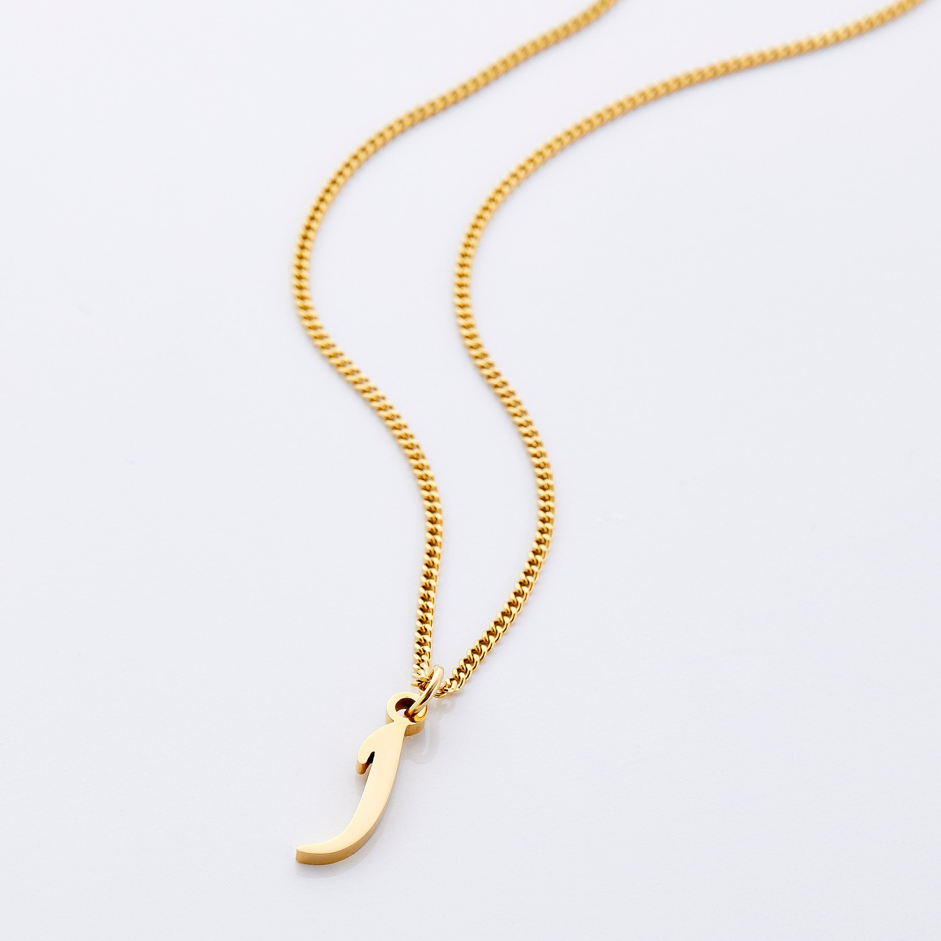 Elegant gold Arabic letter necklace on a model wearing it casually.