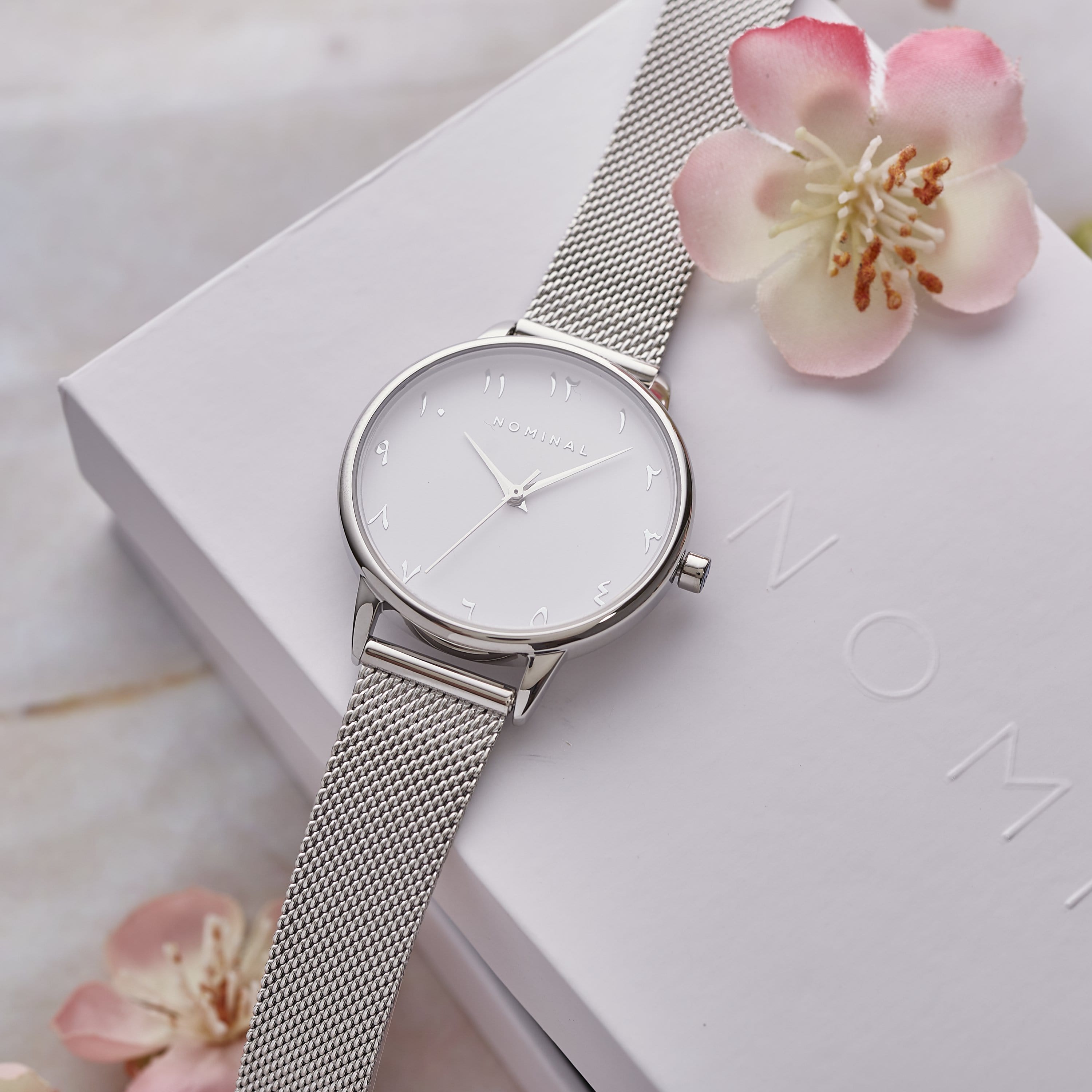 Blanche Elegant Timepiece showcasing the sleek design and Arabic numeral dial from a side angle.