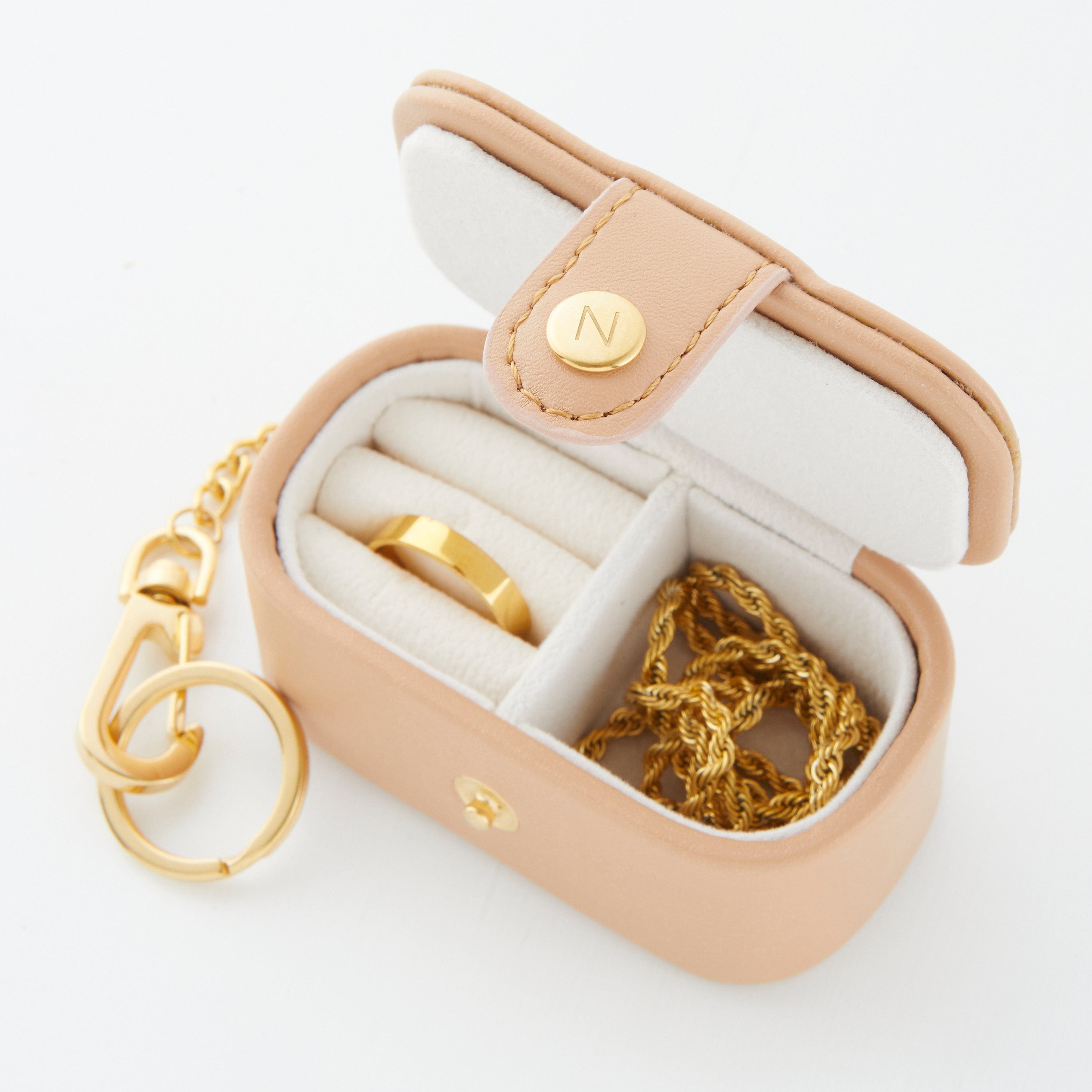 Travel jewelry case showing rings and earrings in organized compartments.