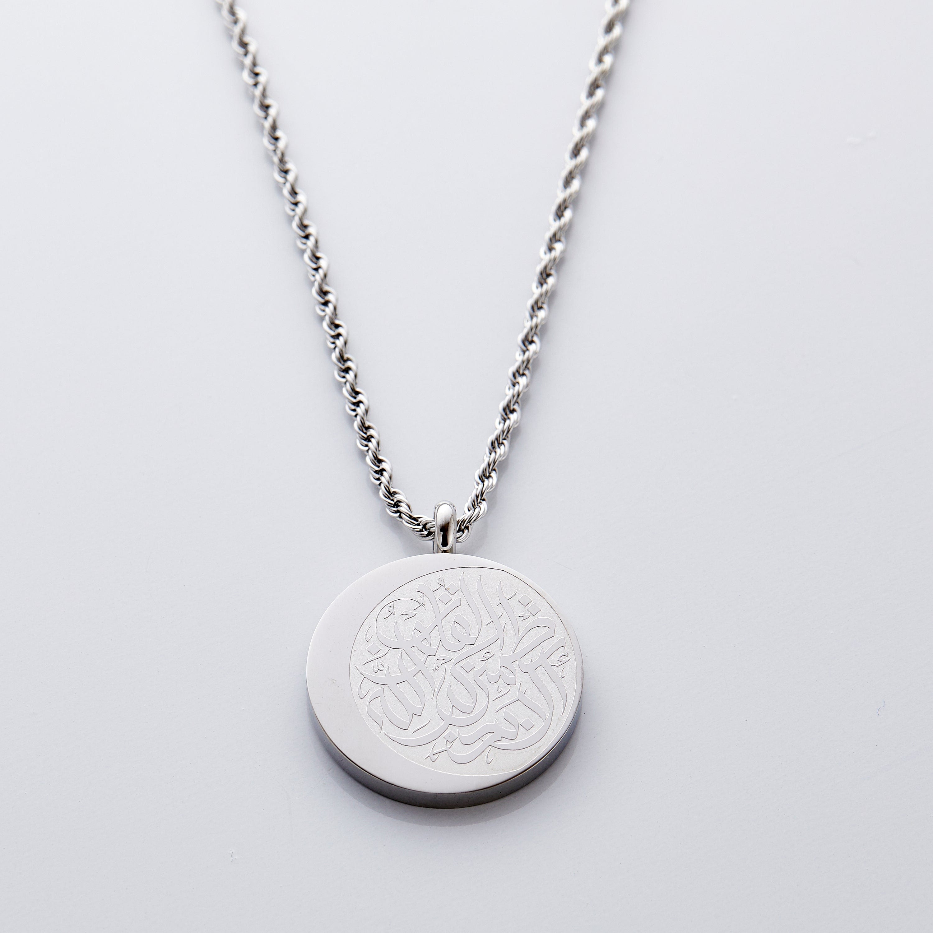 Crescent Allah Remembrance Necklace displayed on a wooden table, showcasing its beautiful design.