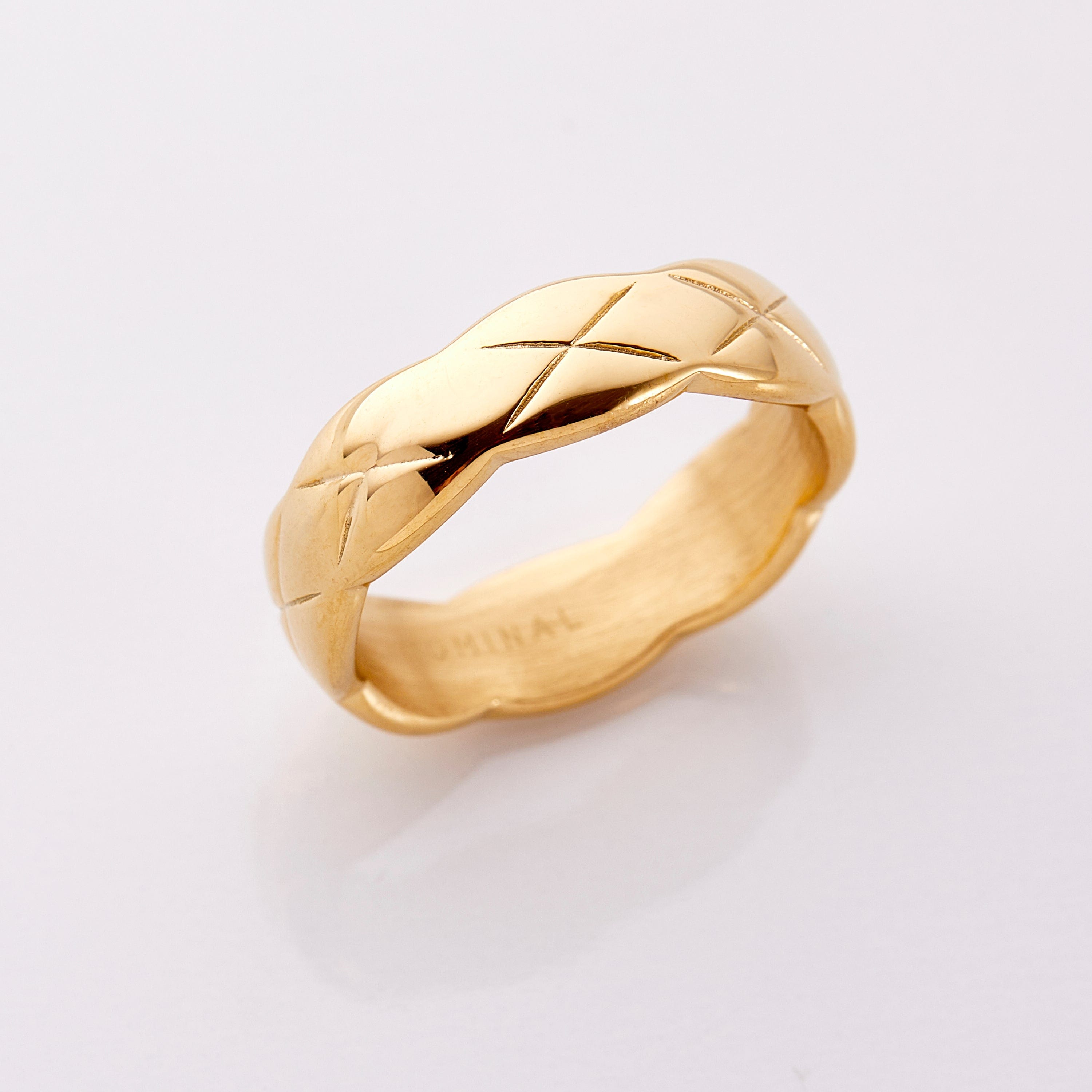 Cozy quilted gold ring displayed on a soft velvet pouch