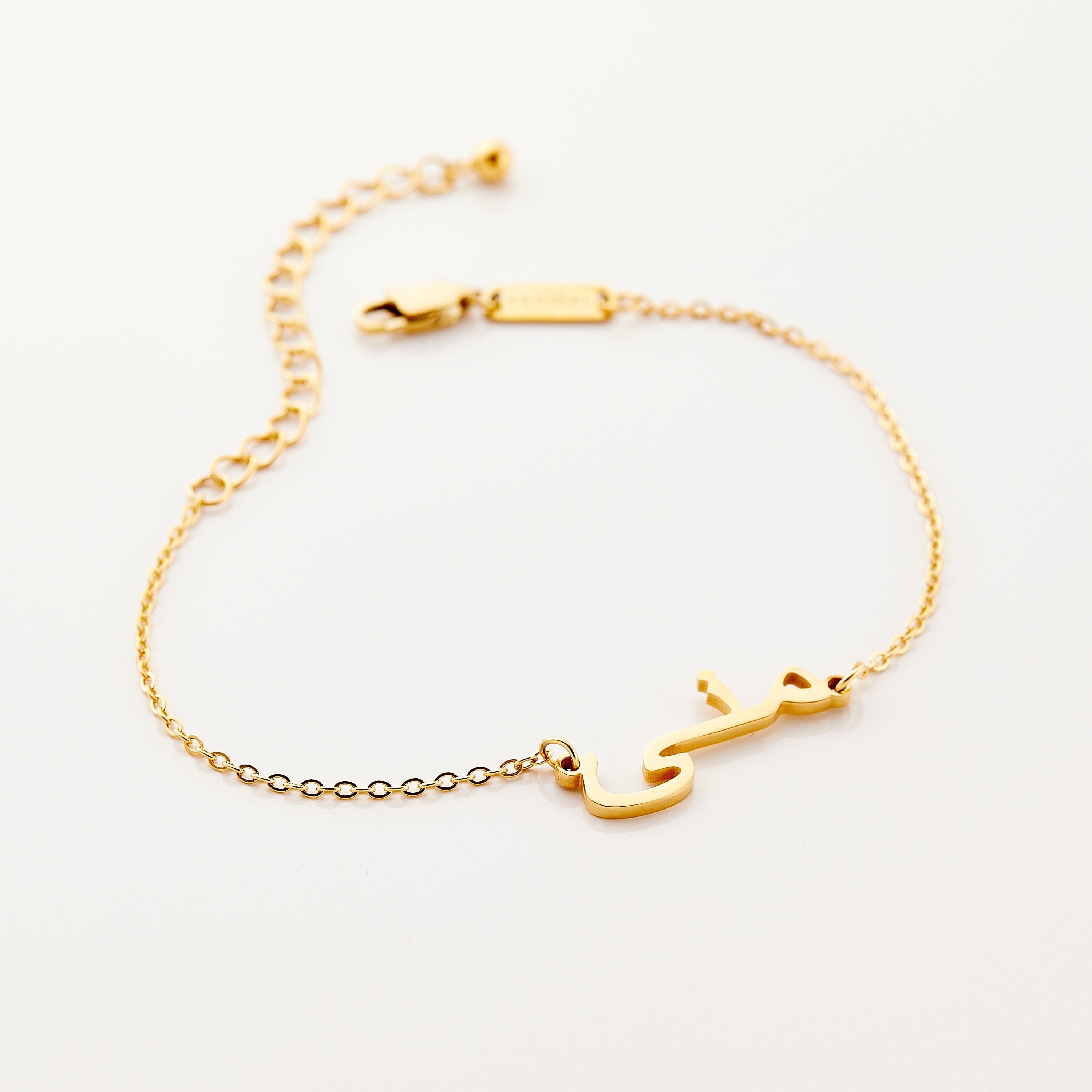 Close-up view of personalized gold name bracelet on a wrist