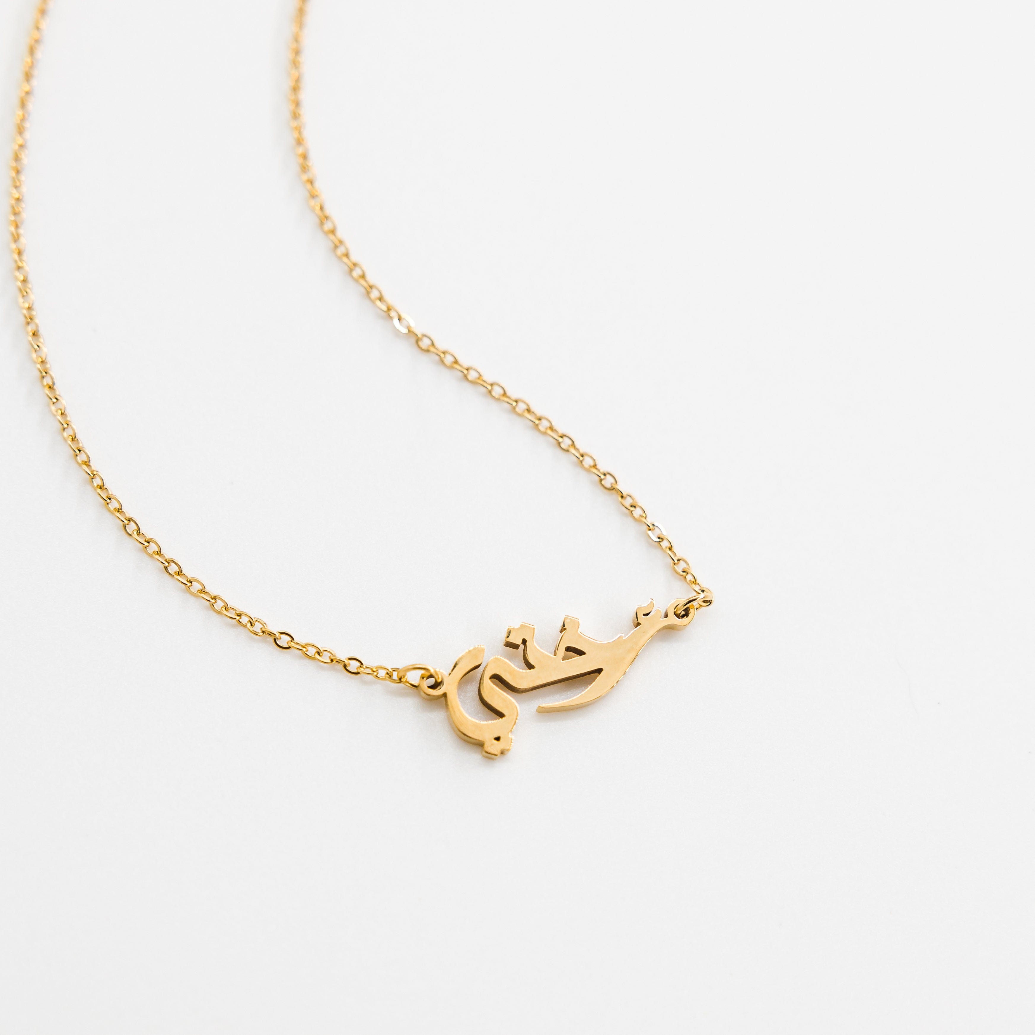 Elegant sister calligraphy necklace with gold plating, displayed on a velvet background.