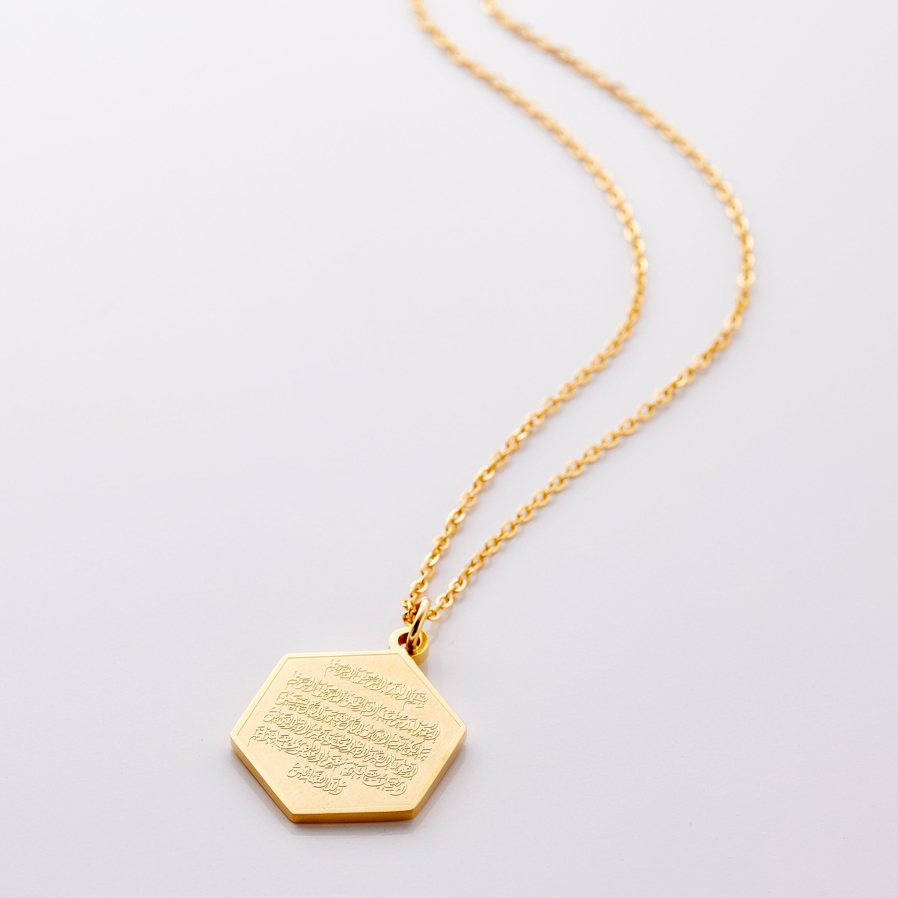 Elegant Surat Al-Fatiha necklace showcasing intricate engraving and gold finish worn elegantly.