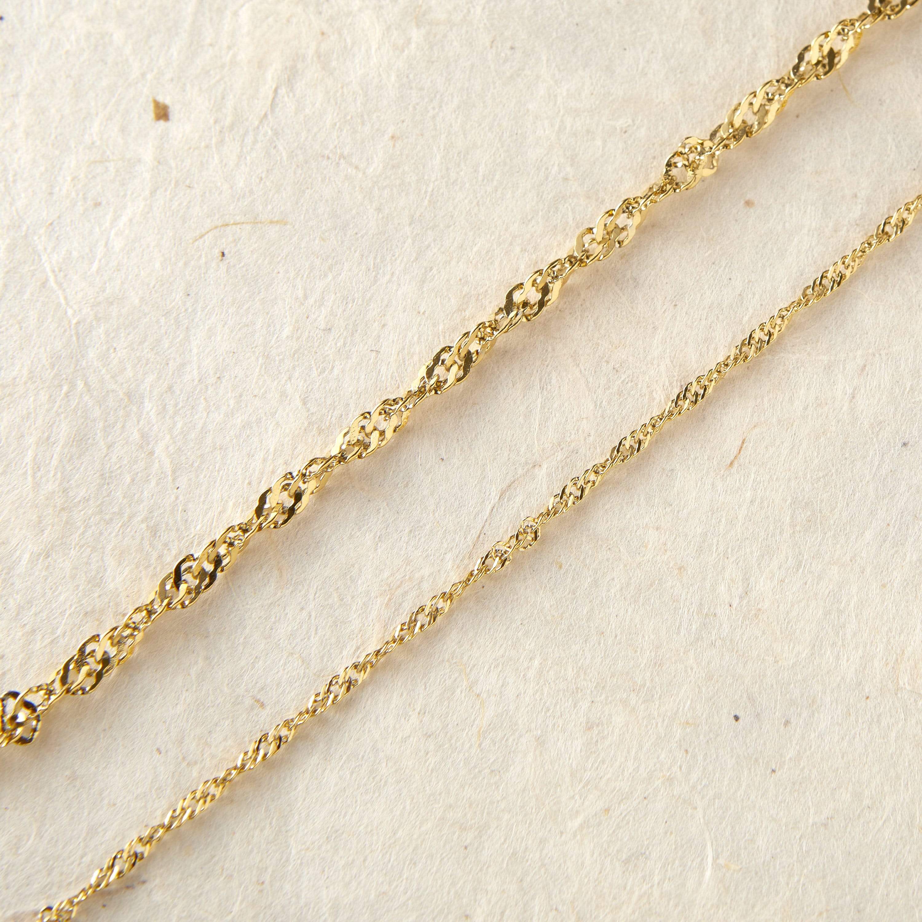 Elegant twisted gold chain anklet worn by a model, showing off its shine and design.