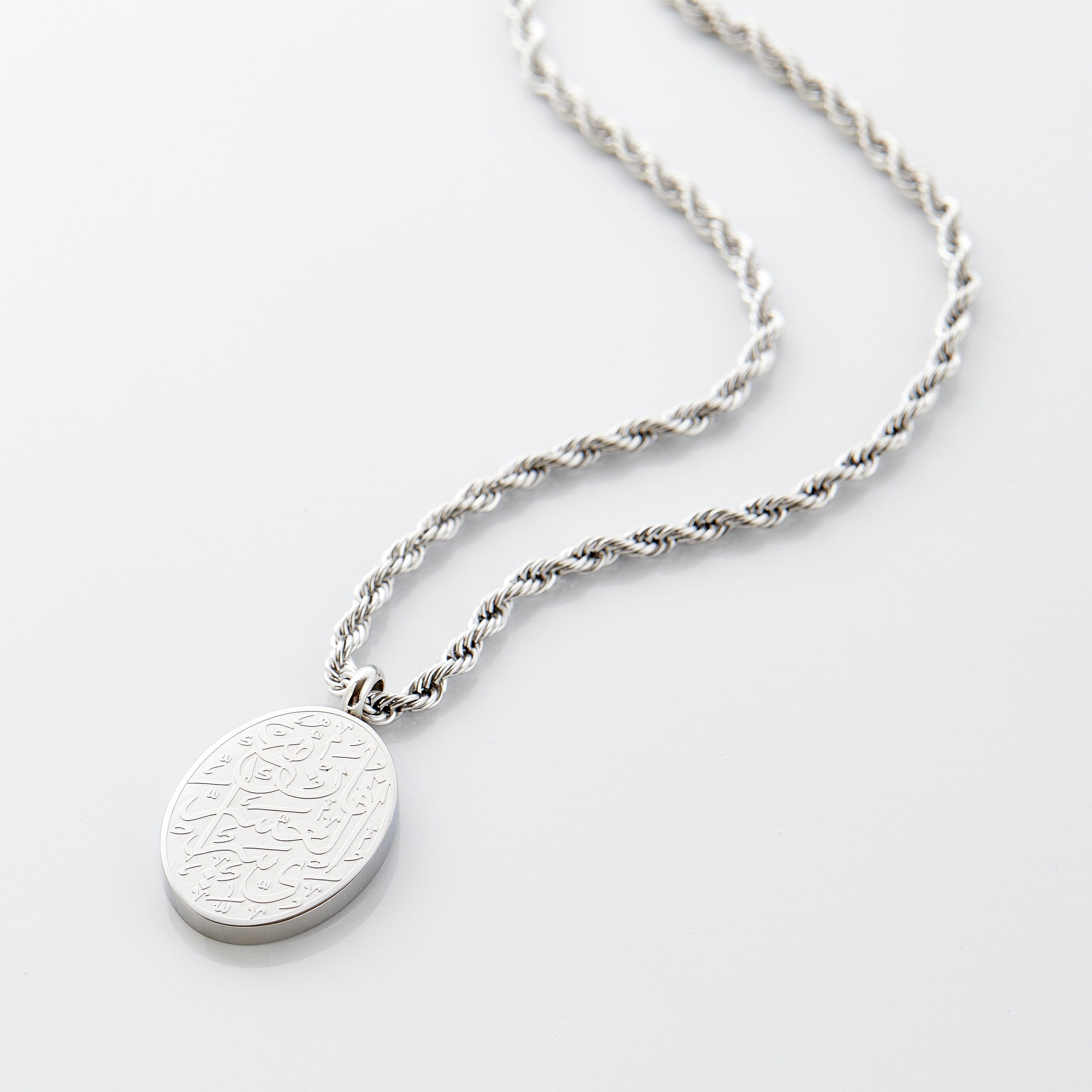 Close-up view of the Resilient Spirit Oval Pendant Necklace, showcasing the elegant engraving and high polish.