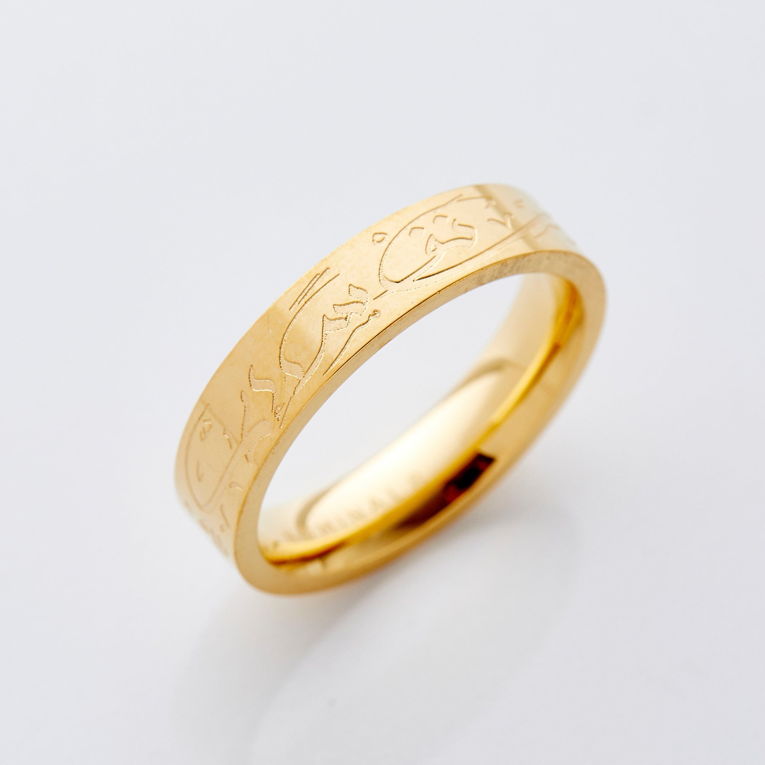 Close-up of the engraved Arabic calligraphy on the gold plated ring, showing intricate detail and shine.